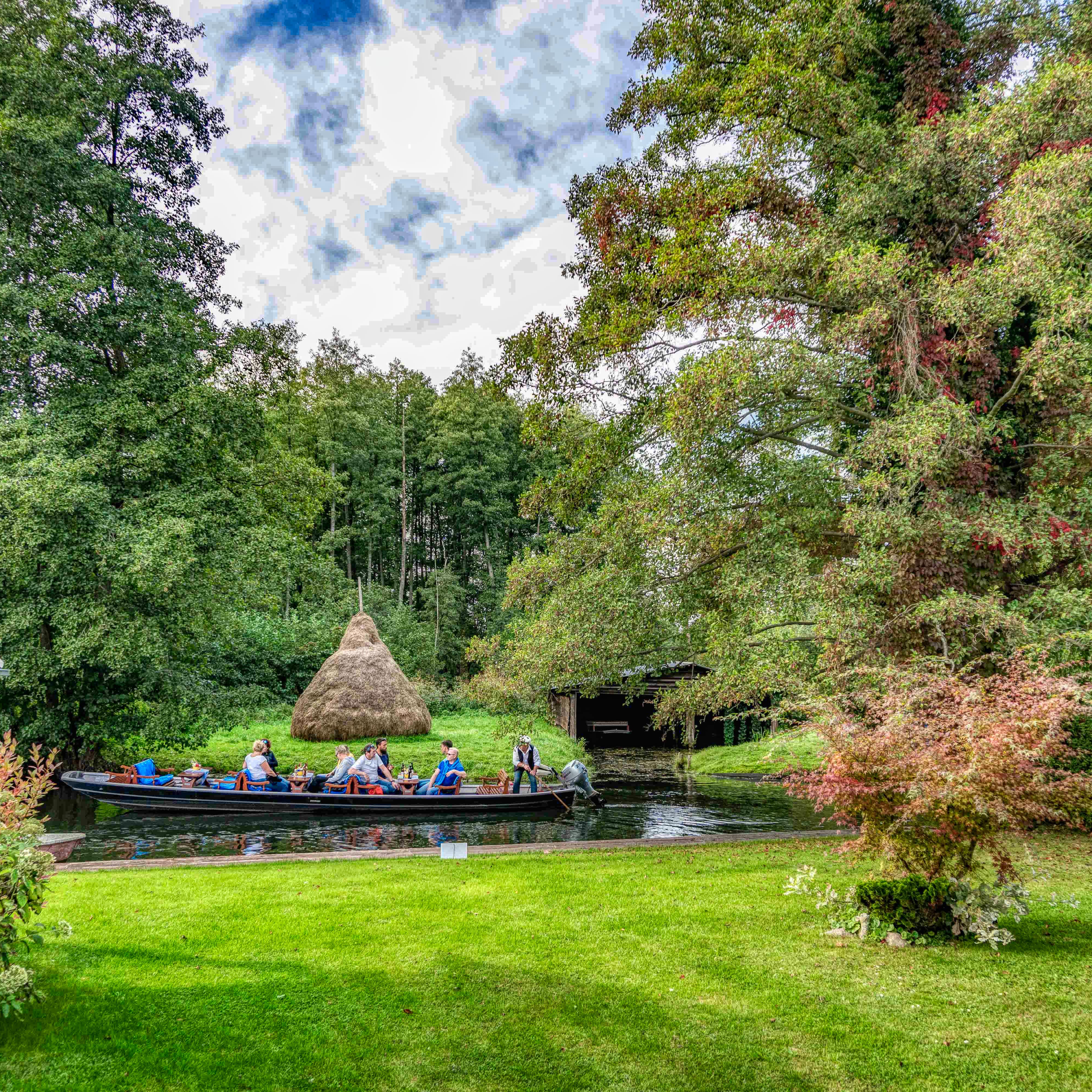 Kahnfahrt auf dem Wasser vorbei an einem Garten in Schlepzig. 