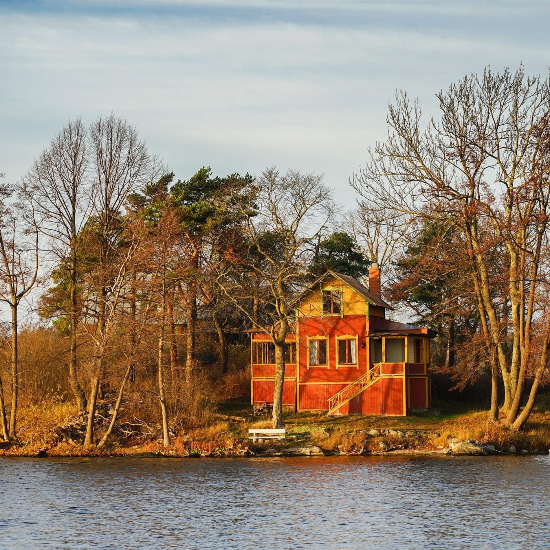 Bungalow am See mit kleinem Angelsteg im goldenen Licht der Abendsonne
