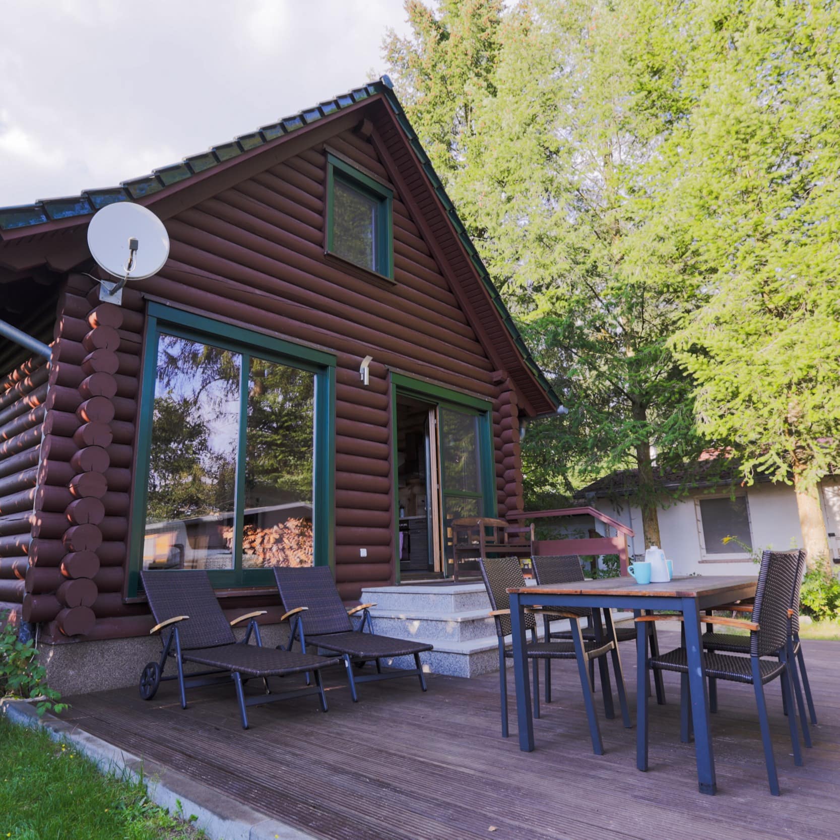 Ein Ferienhaus aus Holz am See mit Terrasse und Garten