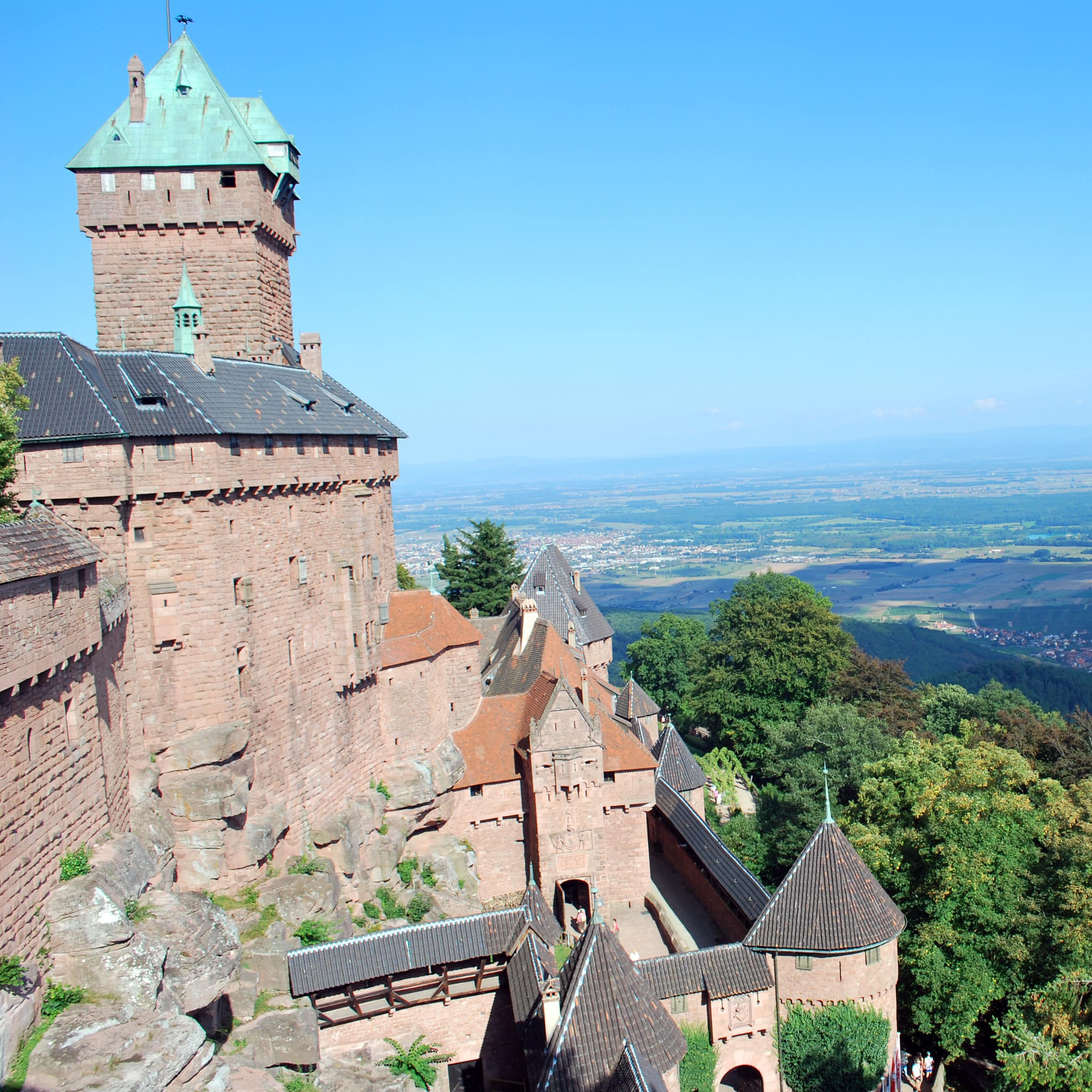 Blick entlang der Hohkönigsburg auf das ländliche Umfeld, rechts Bäume.