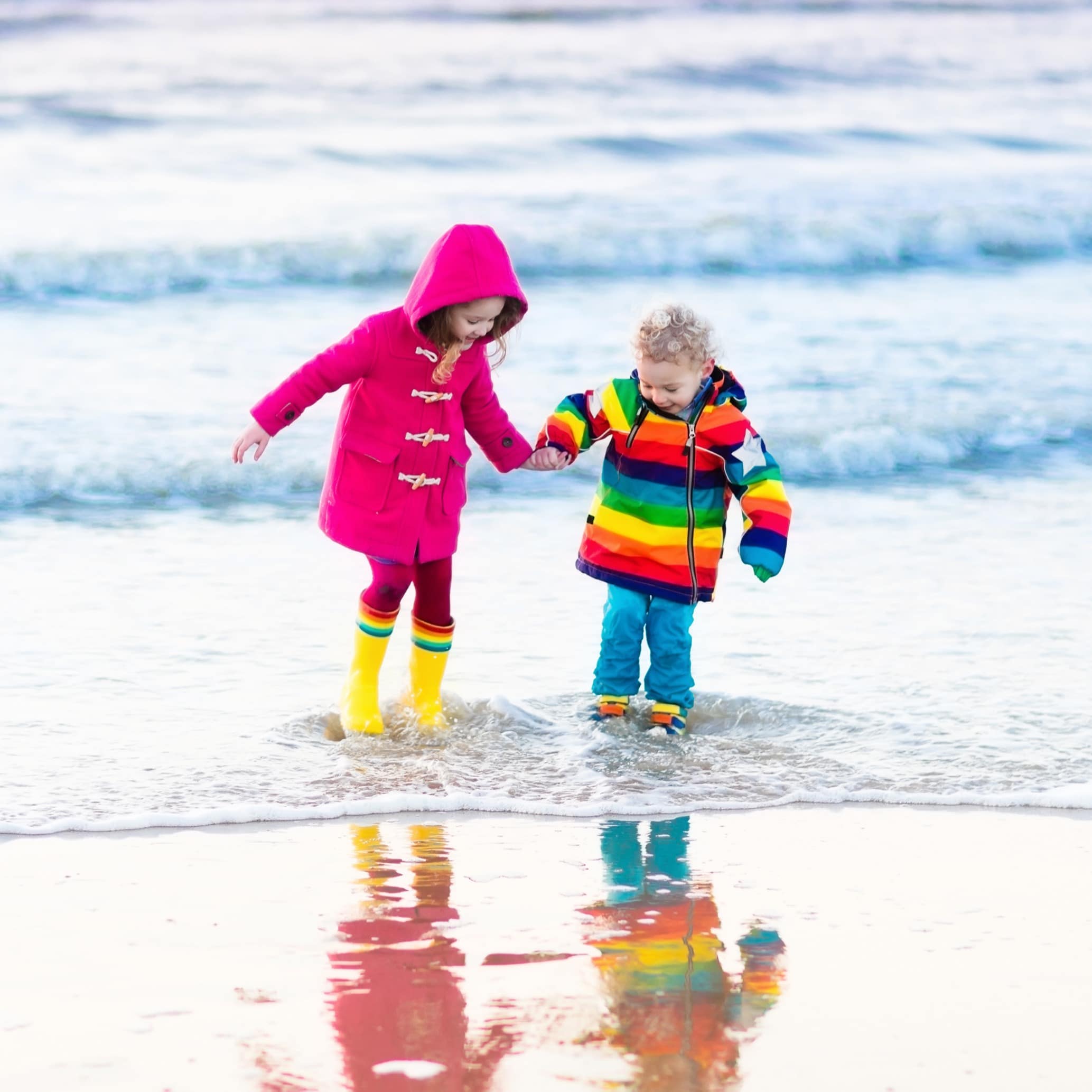 2 junge Mädchen vergraben ihre Füße im Strand an der Nordsee.