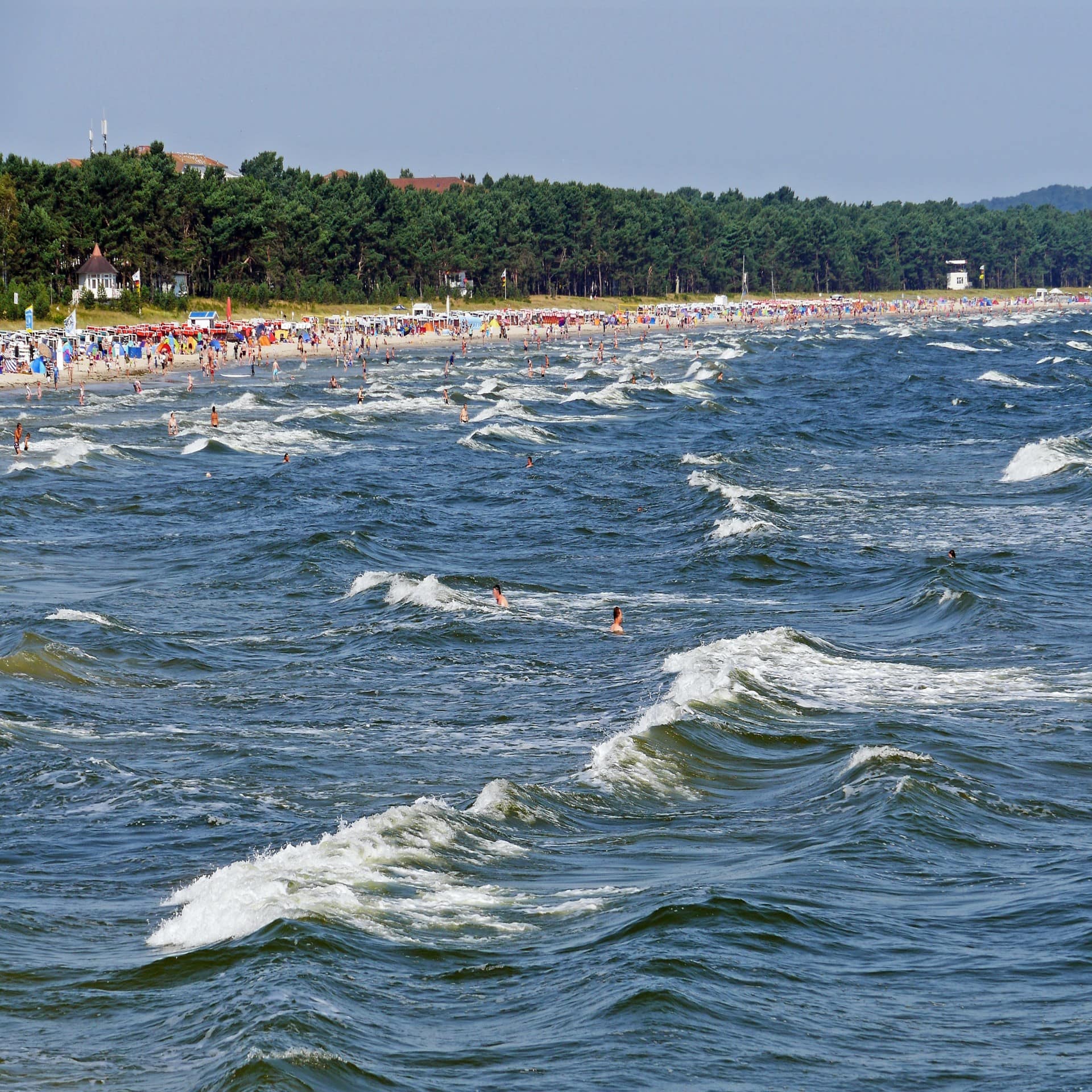 Leute tummeln sich am Strand von Binz und im Wasser 