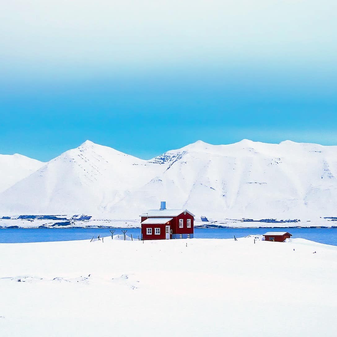 Eine Hütte am See in Skandinavien inmitten einer verschneiten Landschaft