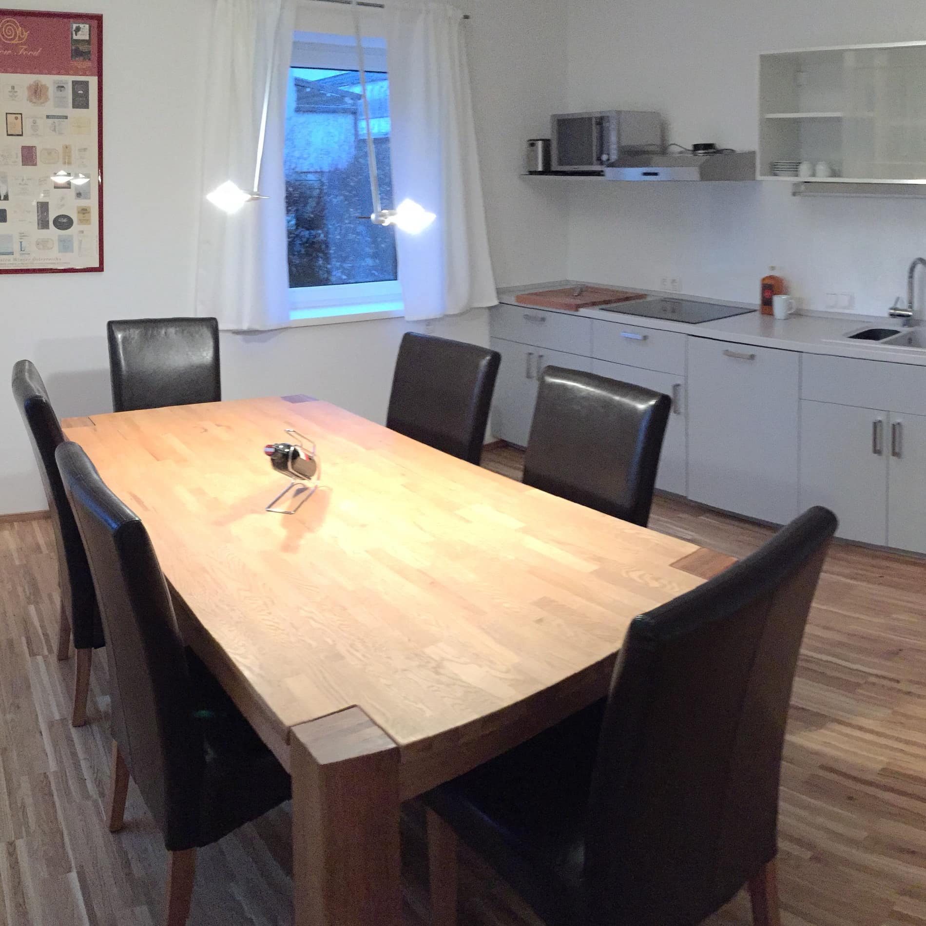 Moderne Küche mit Stühlen um den Tisch in der Ferienwohnung für 8 Personen in Salzburg