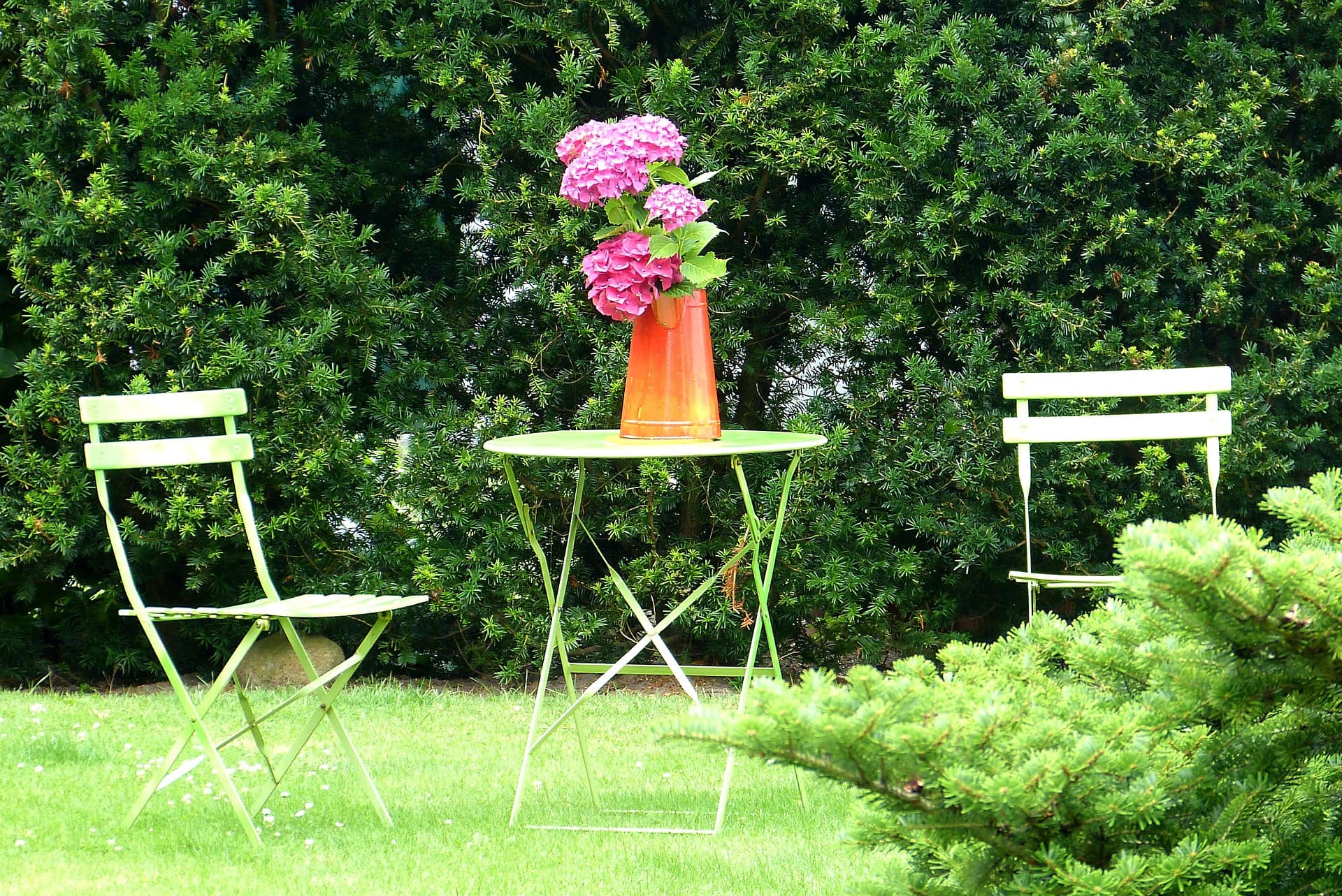 Garten einer Ferienwohnung von Föhr mit Tisch, Stühlen und Blumen