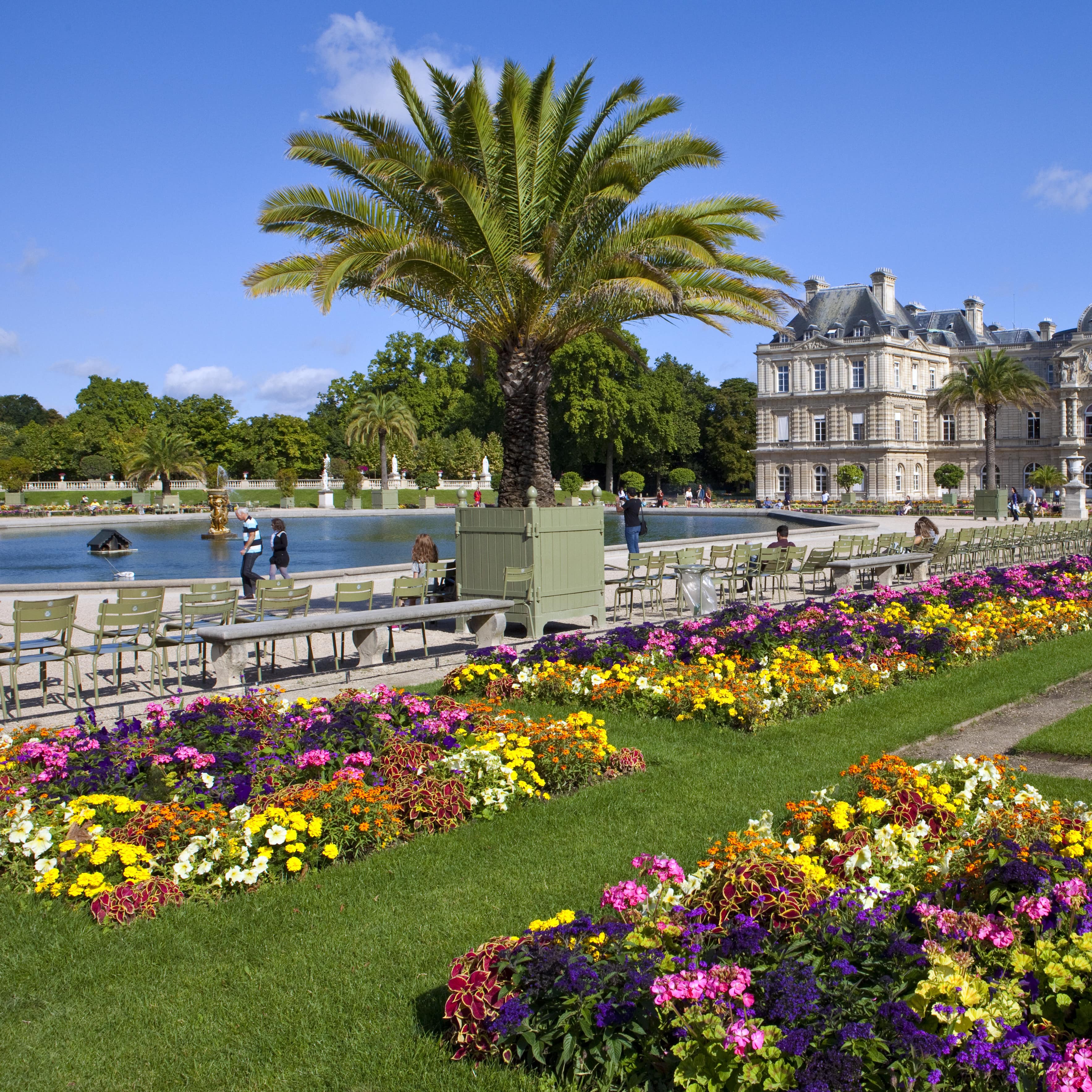 Wiese mit Blumen, davor ein kleiner See und der Luxembourg Palace.