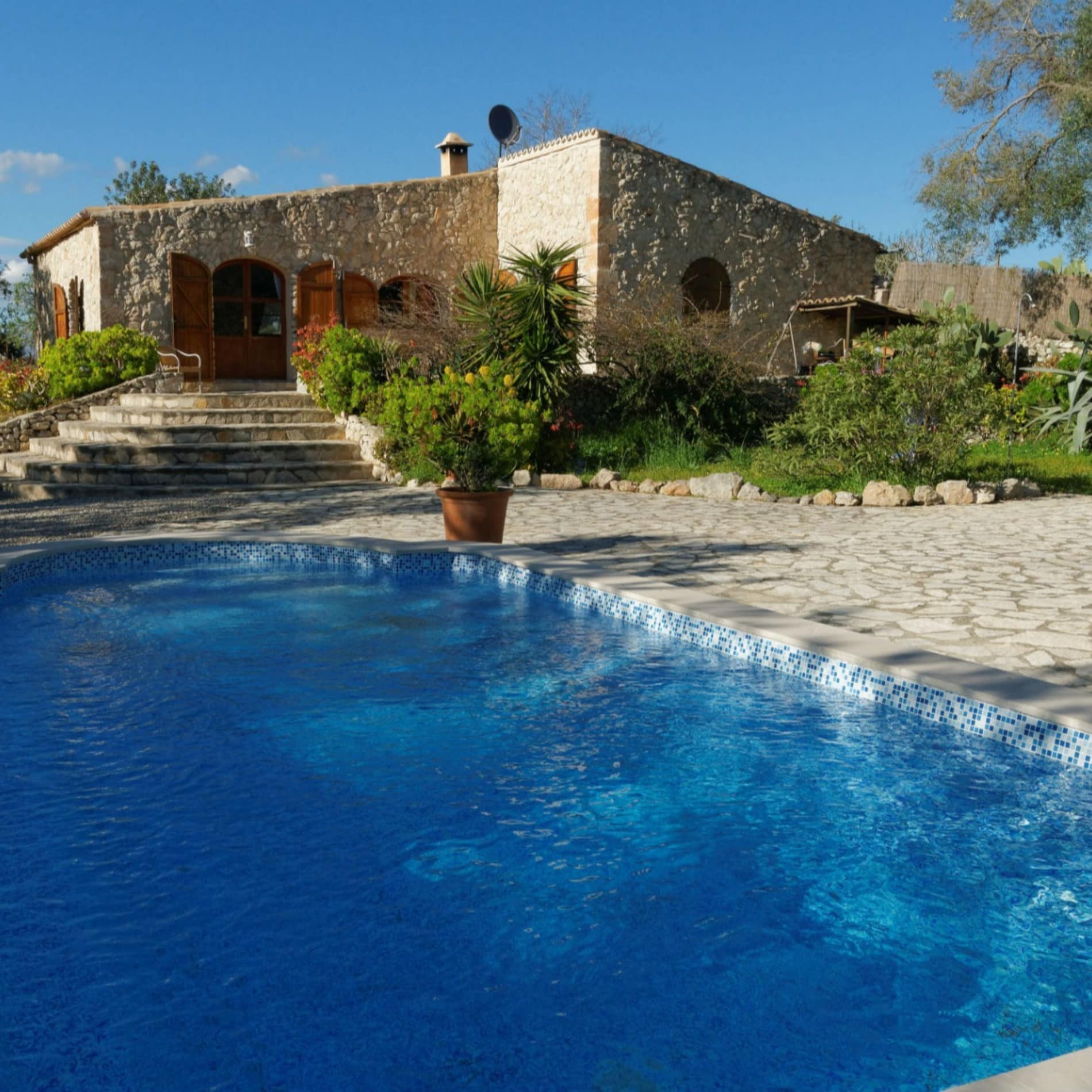 Blick auf einen Bungalow auf Mallorca mit Pool, Terrasse und Garten
