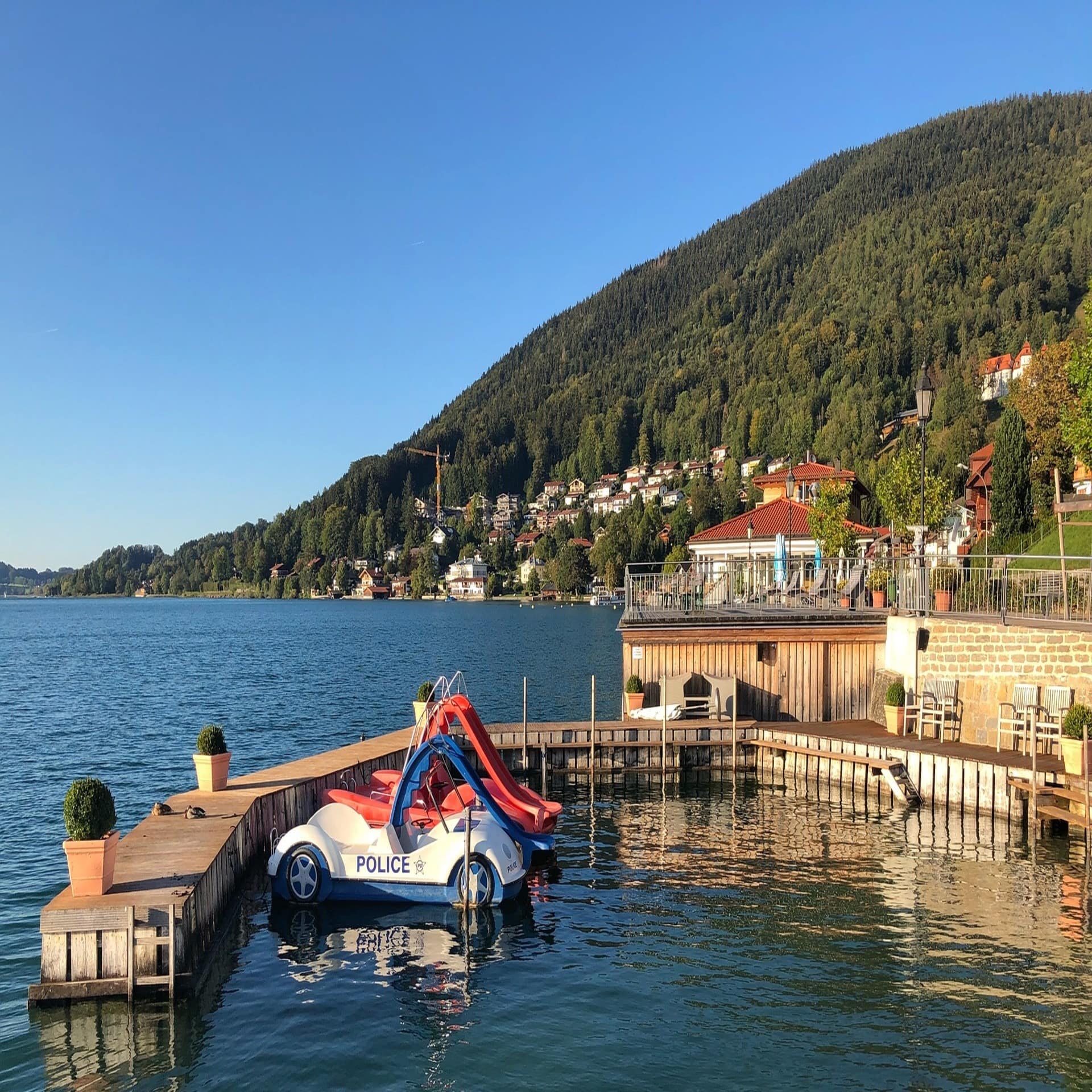 Blick auf 2 autoförmige Tretboote mit Rutschen die an einem geschwundenen Bootsanker ankern.