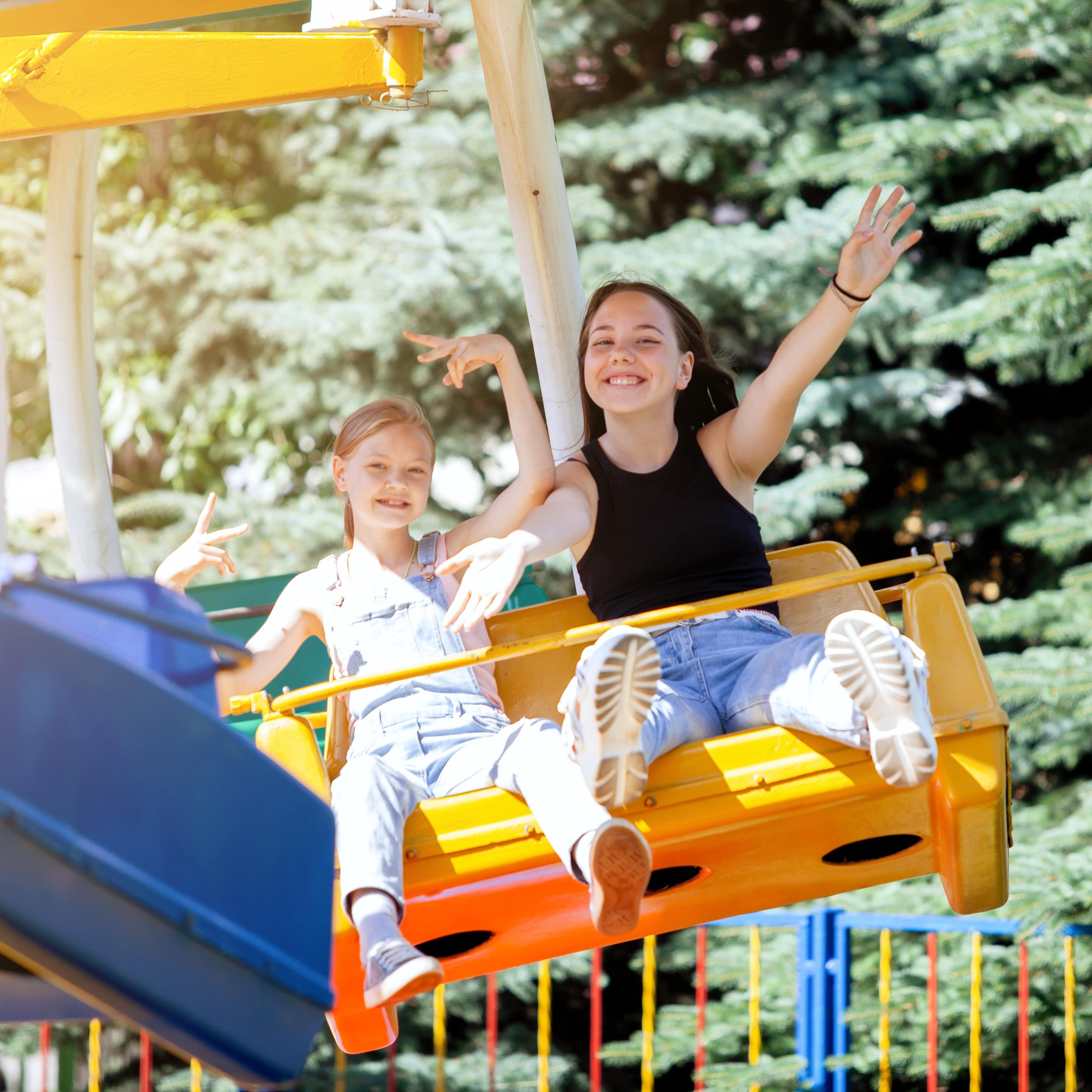 Zwei Mädchen in einem Fahrgeschäft im Freizeitpark