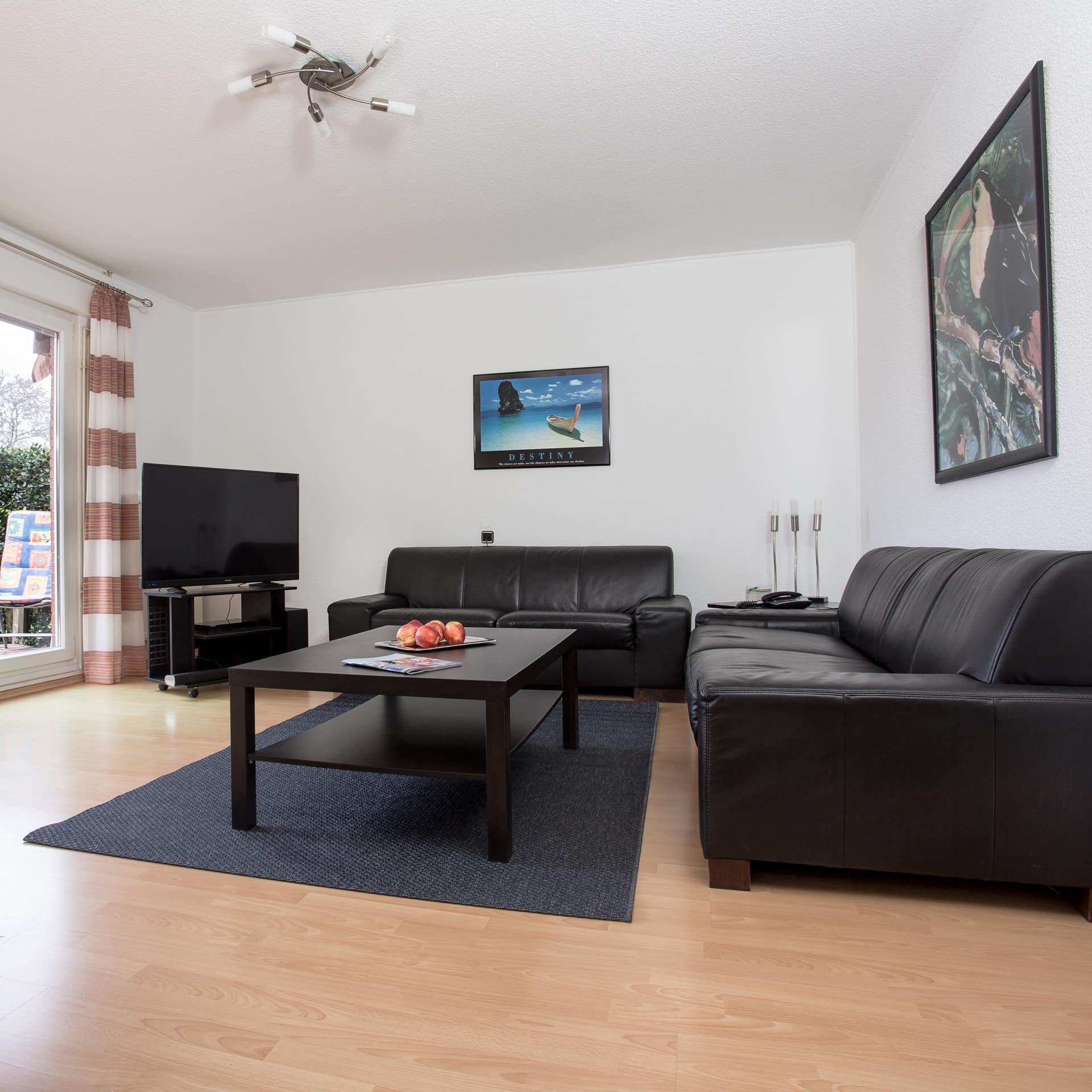 Modern eingerichtetes Wohnzimmer einer Fehmarner Ferienwohnung mit Garten