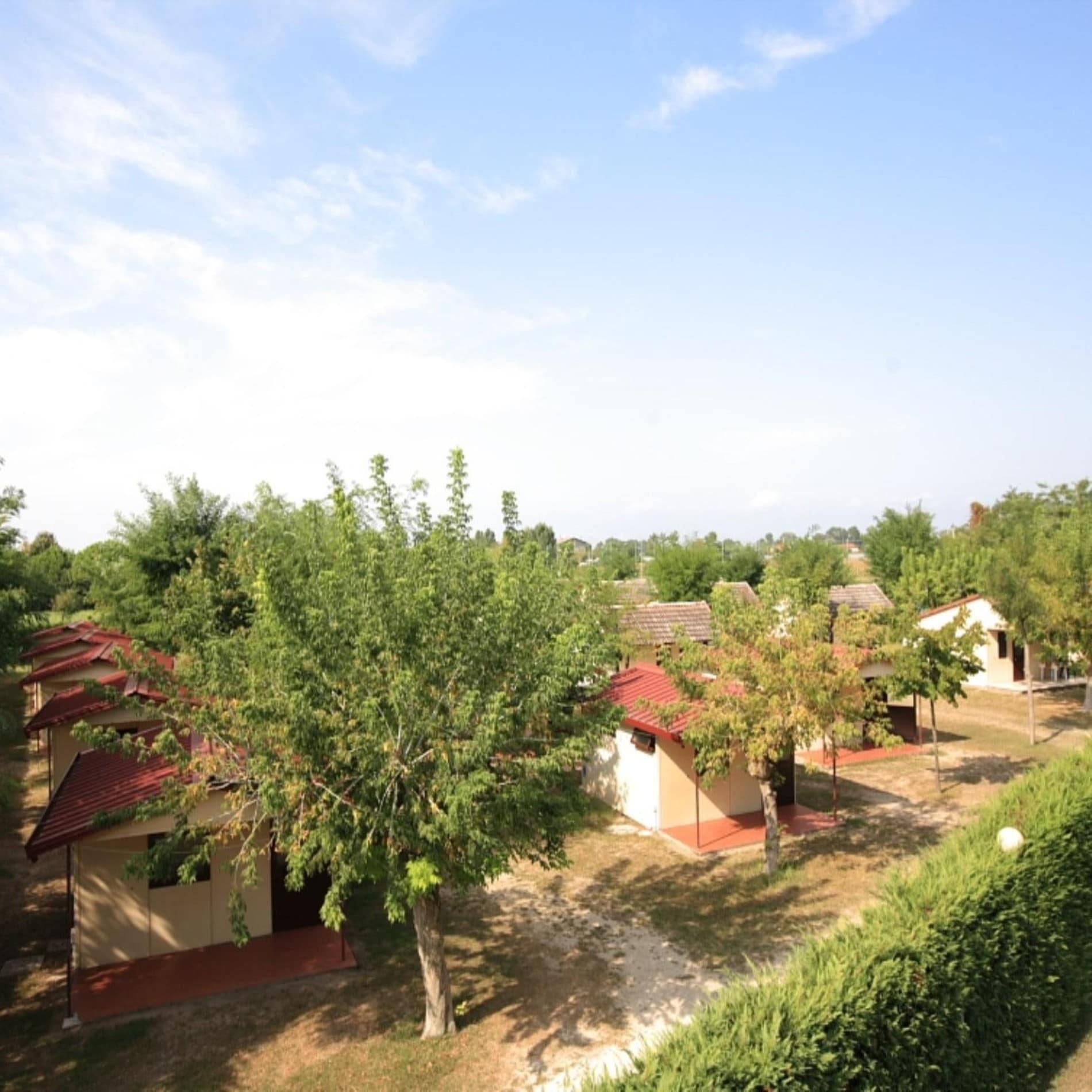 Bungalowanlage in Jesolo mit Hecke und Bäumen