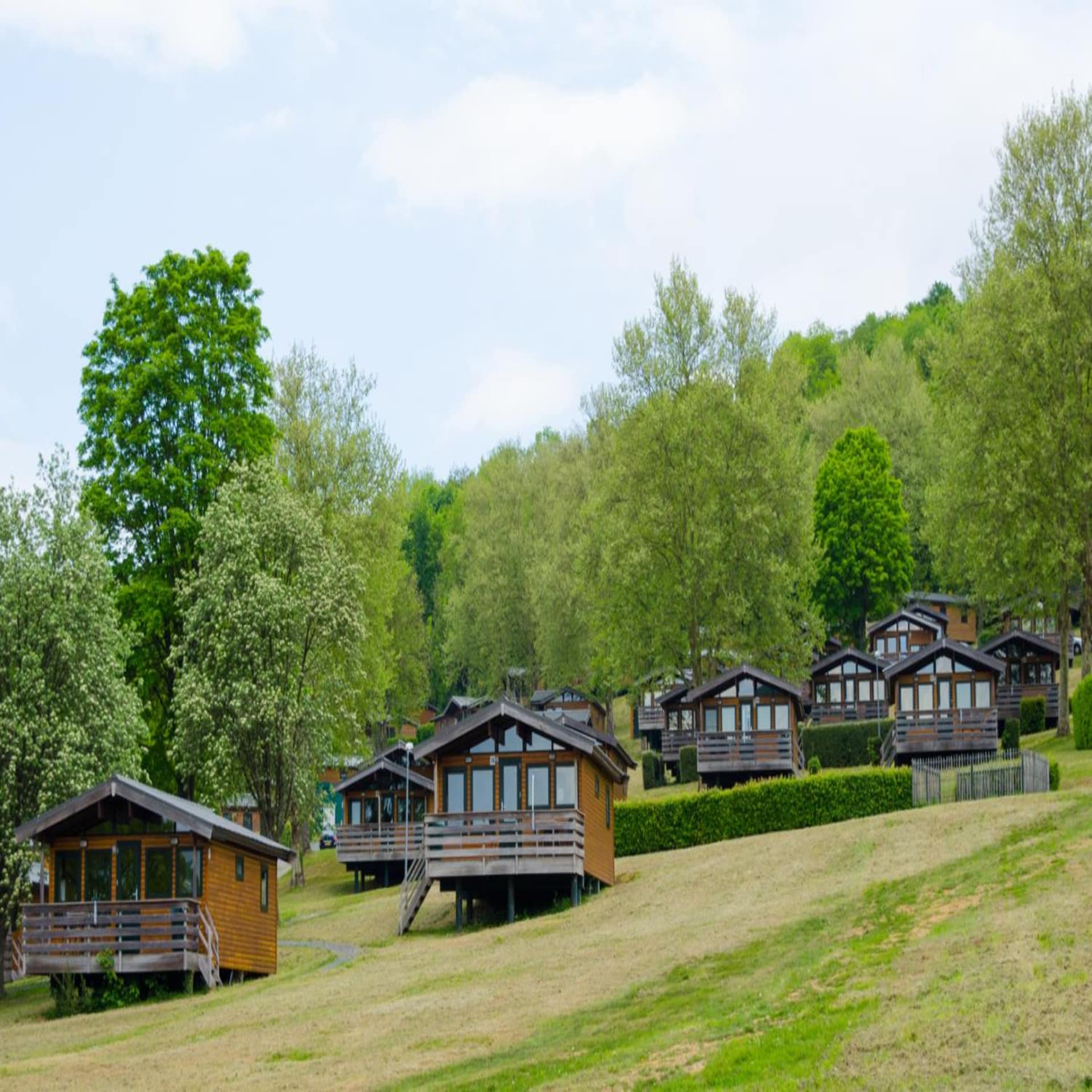 Blick auf kleine Holzhäuser in einem Ferienpark im Grünen