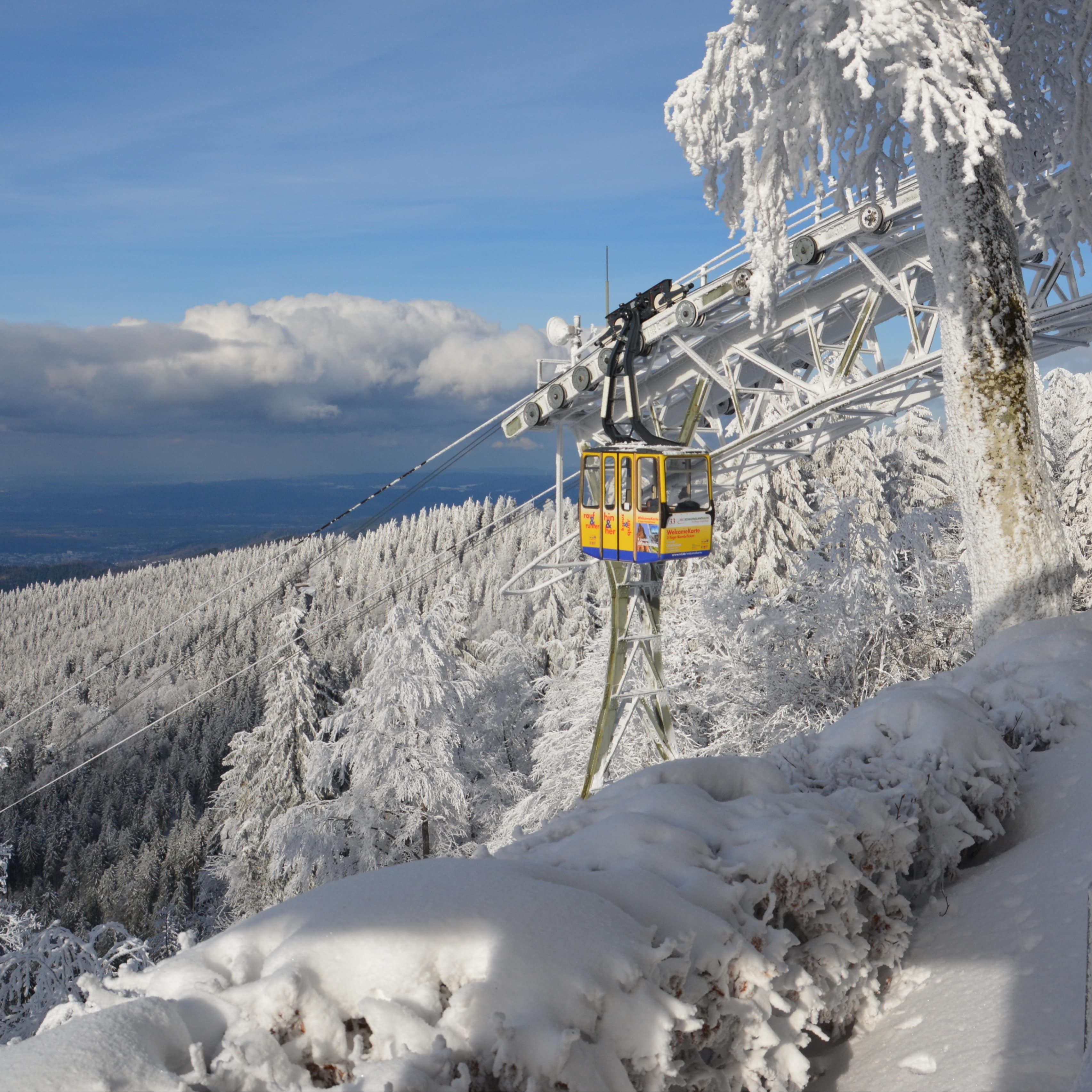 Die gelbe Kabine der Schauinslandbahn in verschneiter Winterlandschaft.