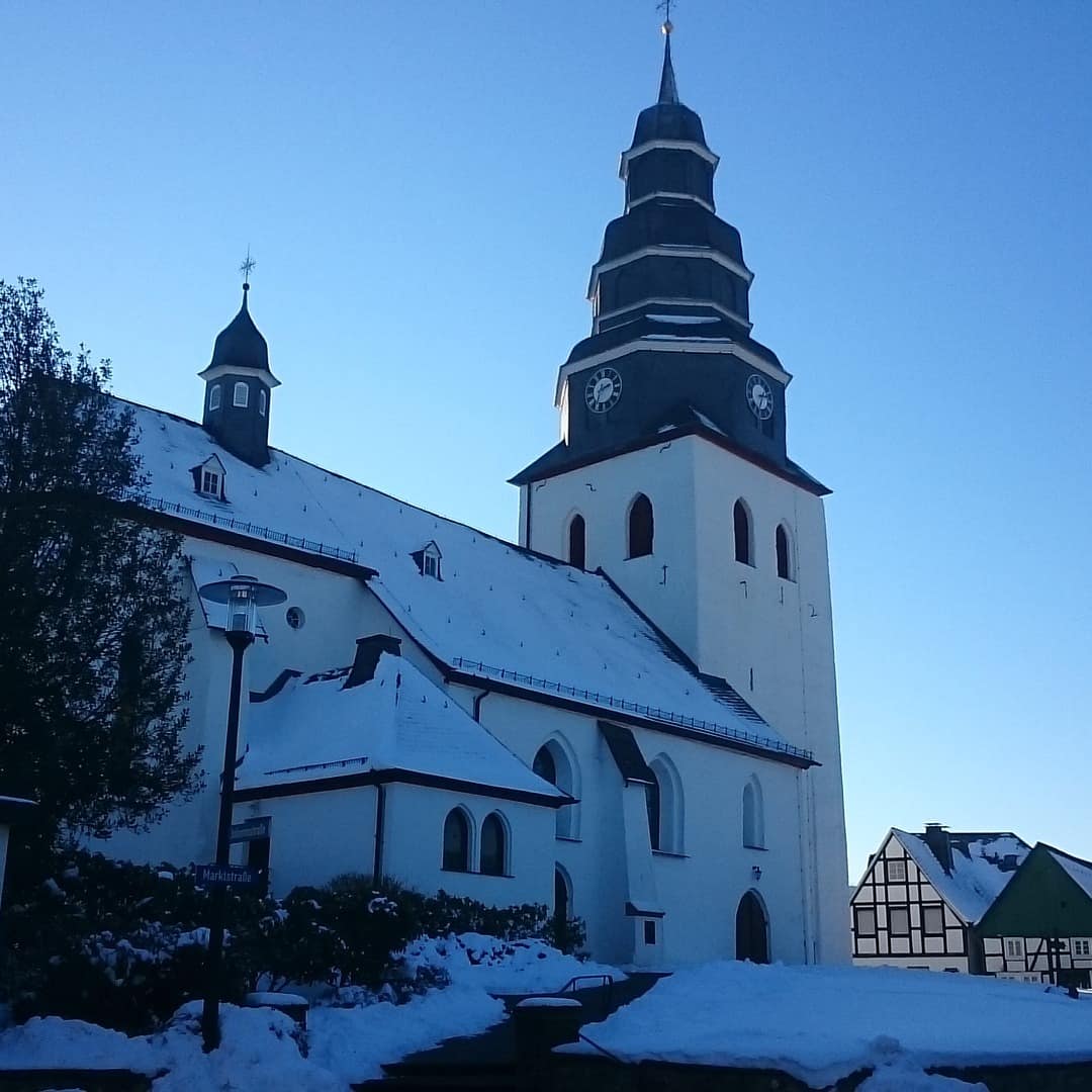 Blick auf eine verschneite Kirche und Fachwerkhäuser im Sauerland