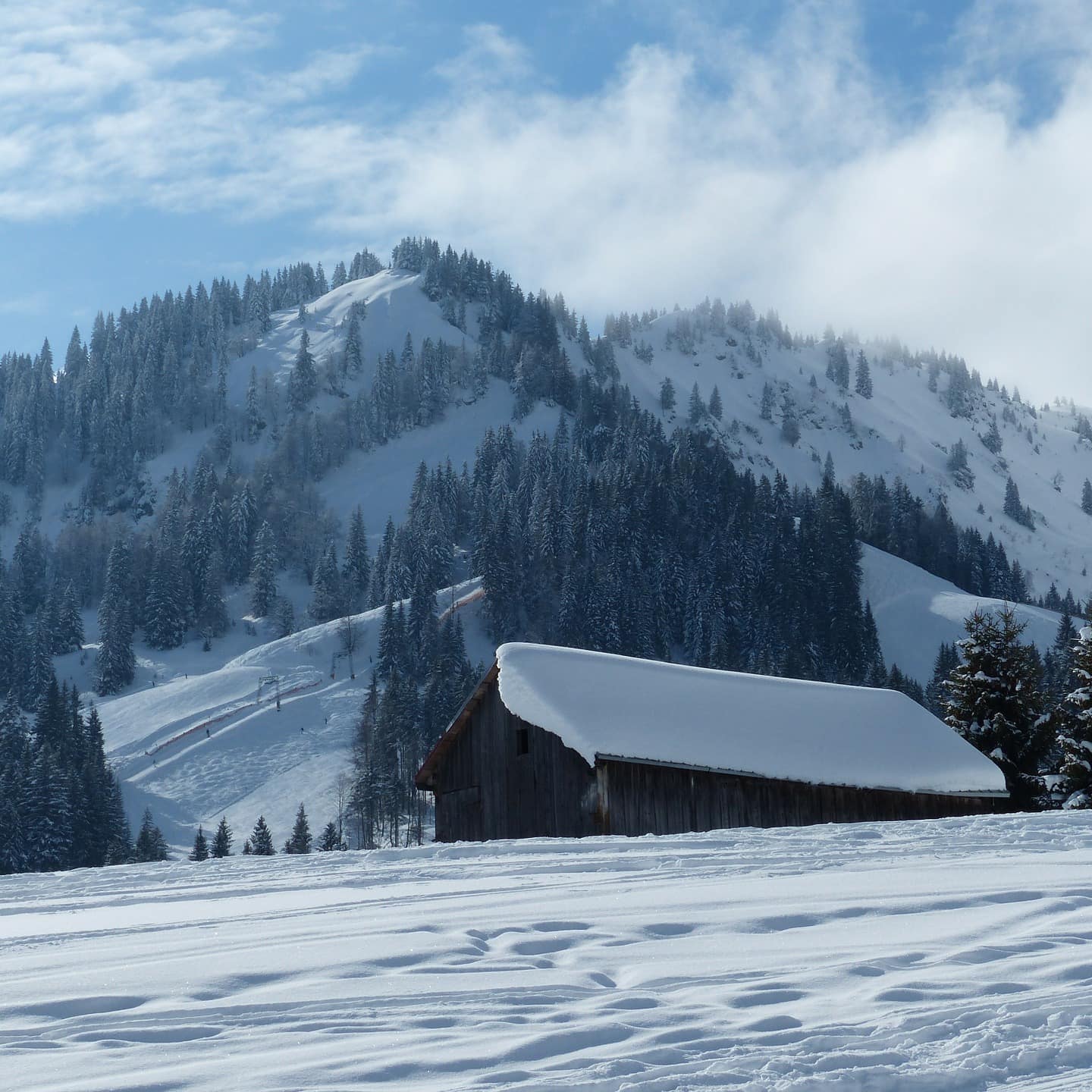 Berghütte im Allgäu im Winter inmitten einer verschneiten Landschaft