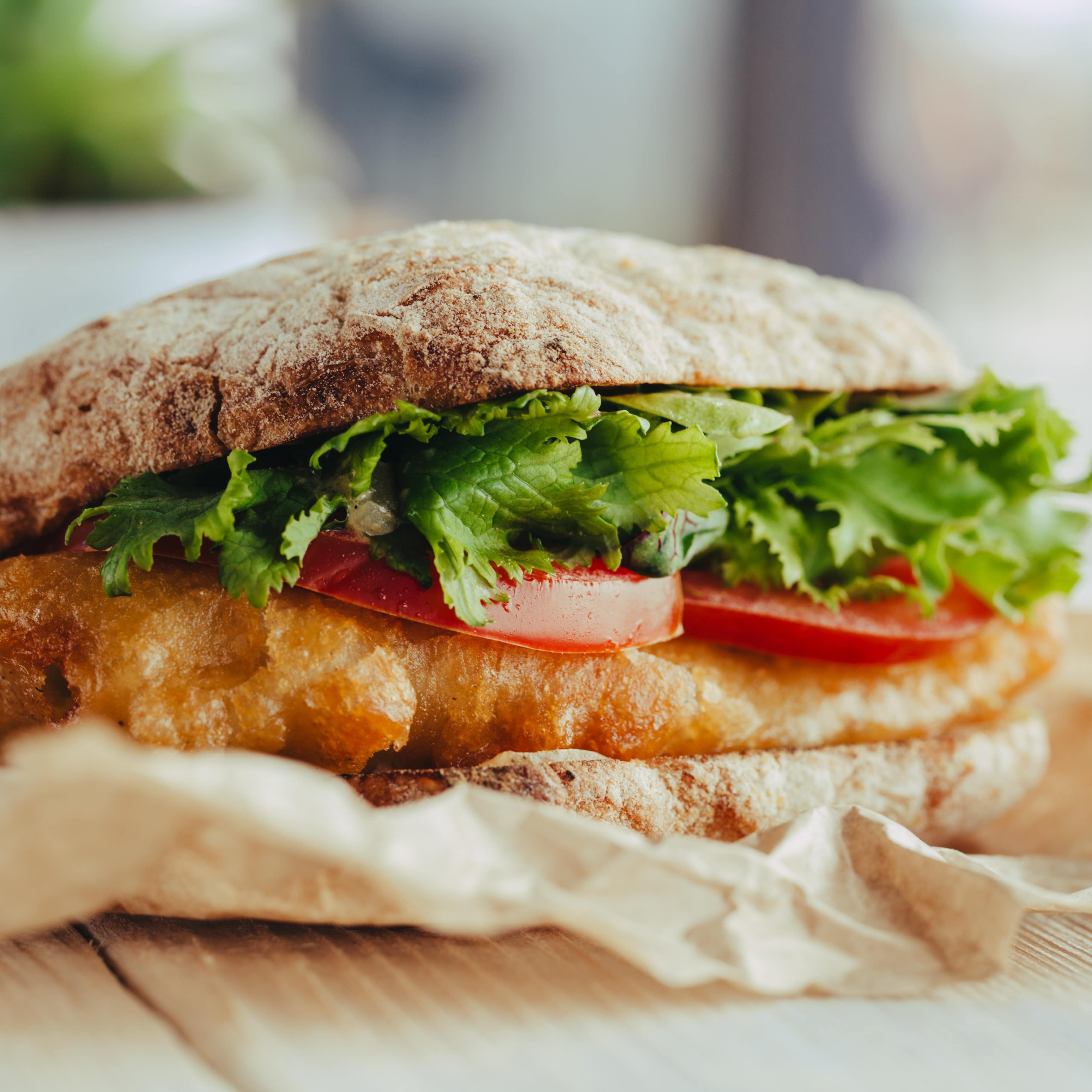 Nahaufnahme: Fischbrötchen mit Salat und Tomaten.