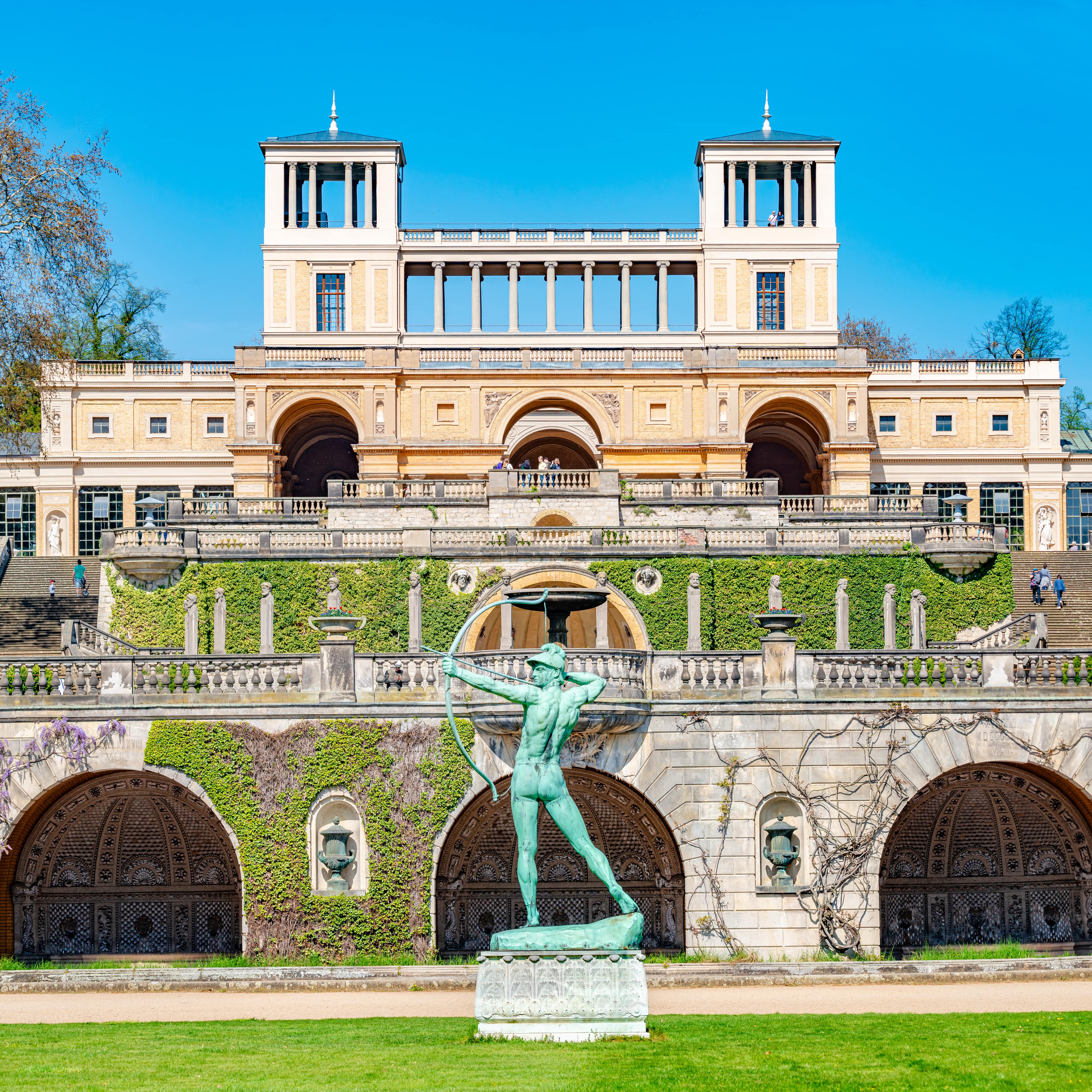 Antike Statue eines Bogenschützen auf einer Wiese im Schlosspark Sanssouci