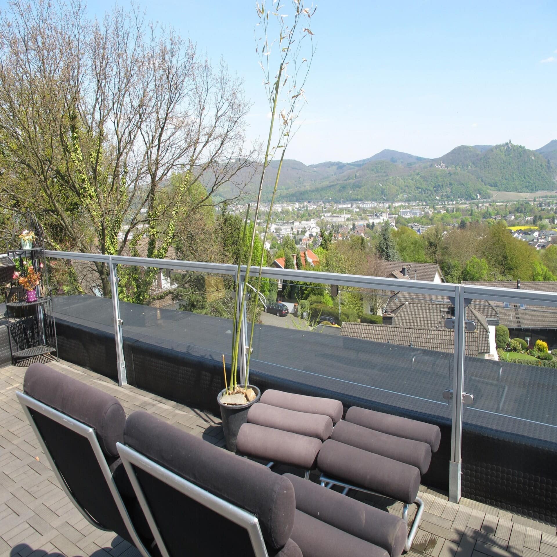 Dachterrasse mit Sitzgelegenheiten und Blick auf einen Vorort von Bonn. Die Sonne scheint.