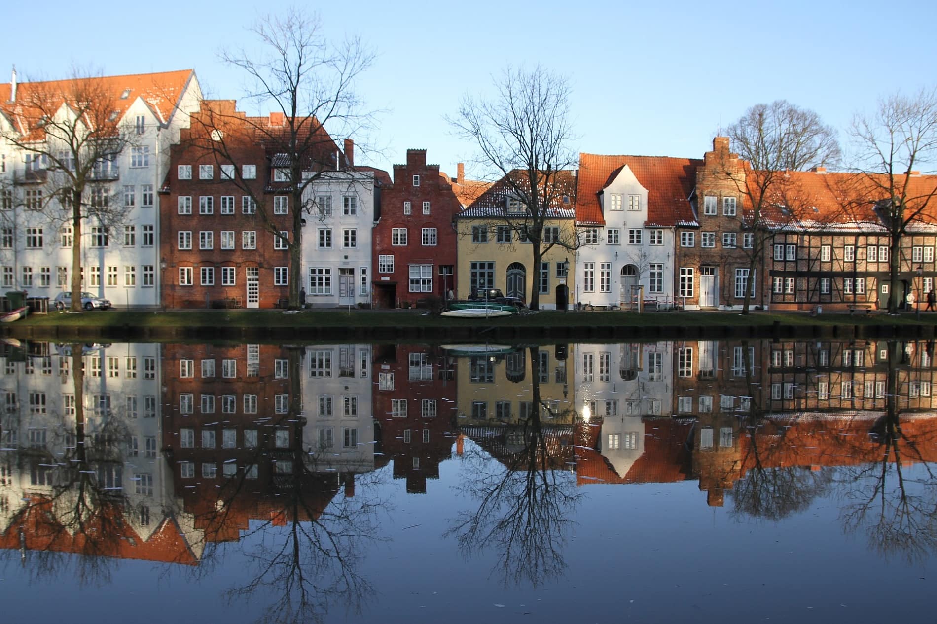 Blick auf Häuser in der Lübecker Altstadt im Winter, die sich im Wasser spiegeln