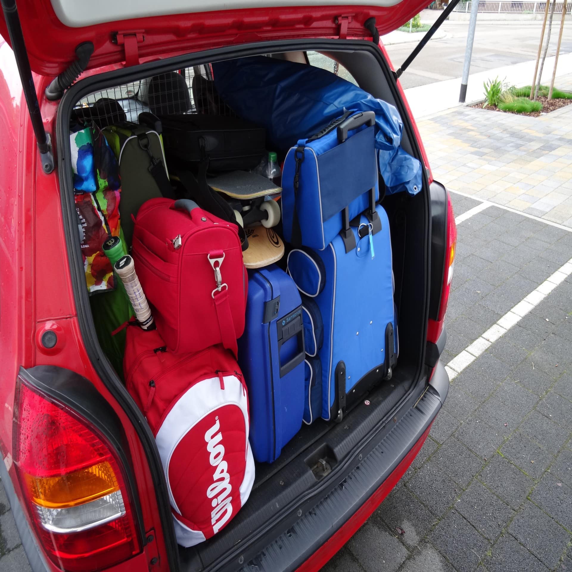 Vollgepackter Kofferraum eines roten Autos. 