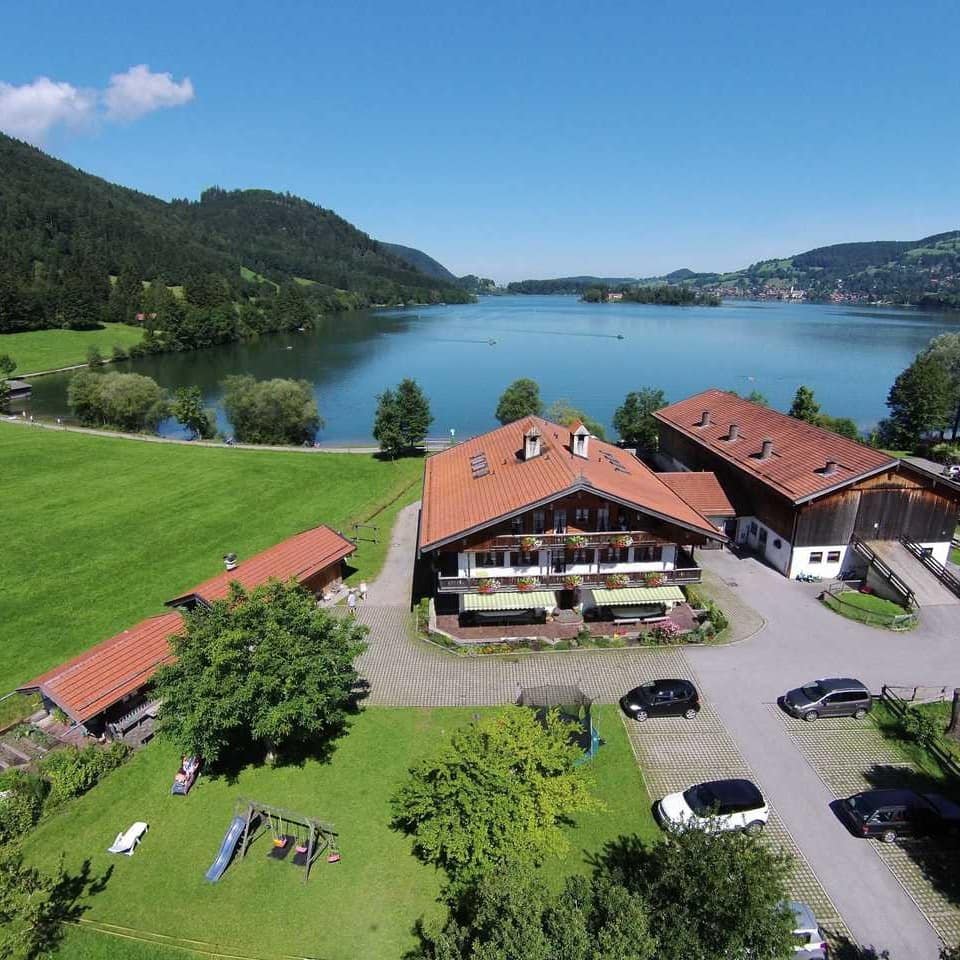 Blick von oben auf ein Haus in Oberbayern mit Ferienwohnungen direkt am See