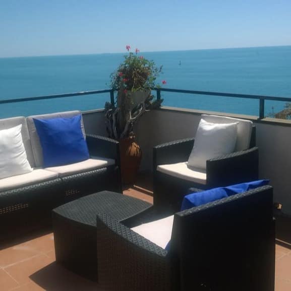 Dachterrasse mit Sitzgelegenheiten und Meerblick einer Ferienwohnung in Italien am Meer