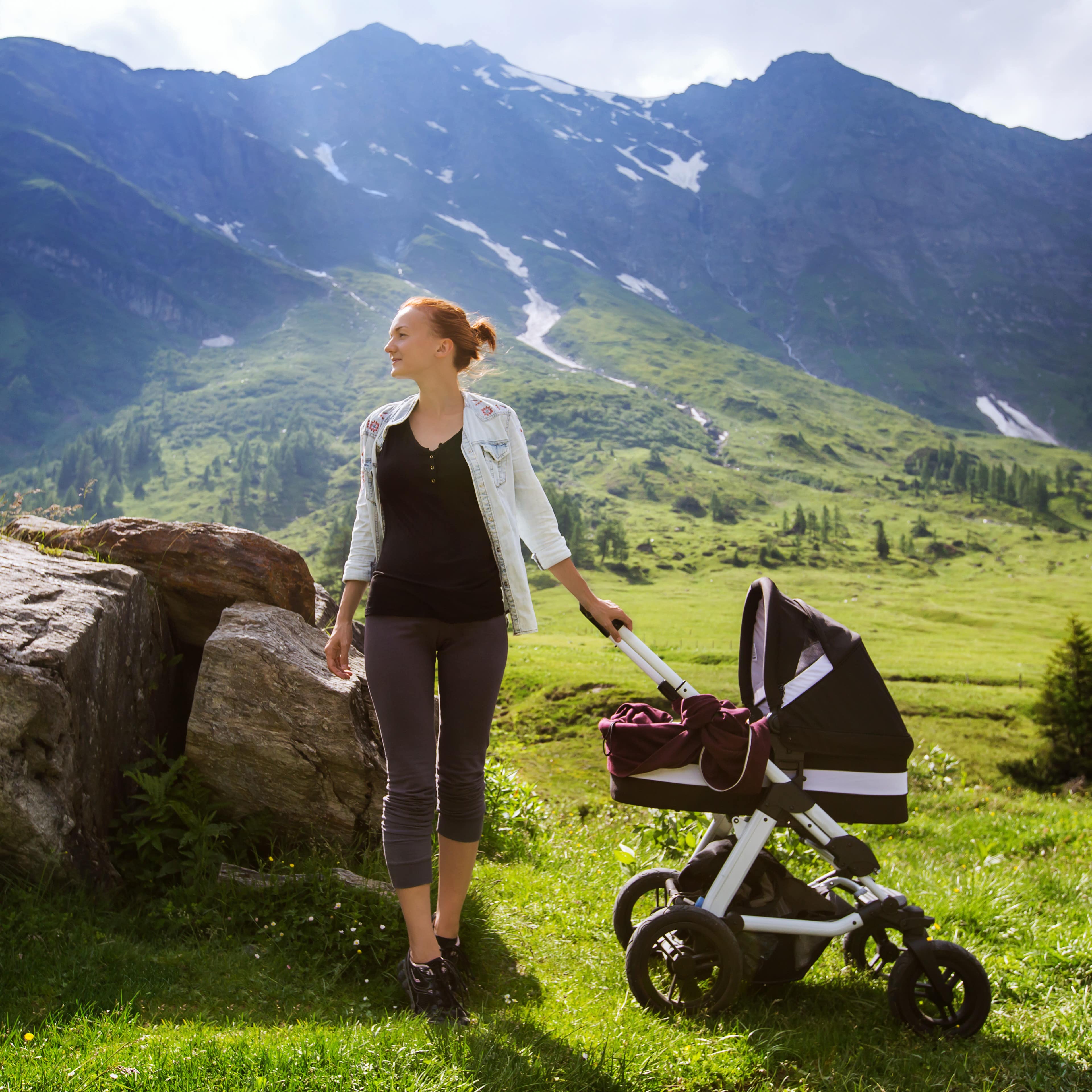 Eine Mutter mit Kinderwagen in den Bergen