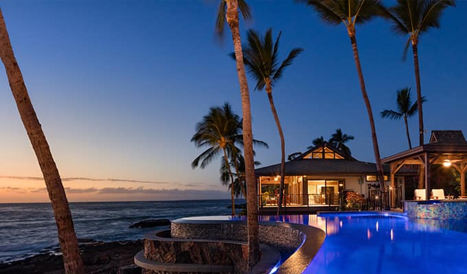 house by the beach with palm trees at night