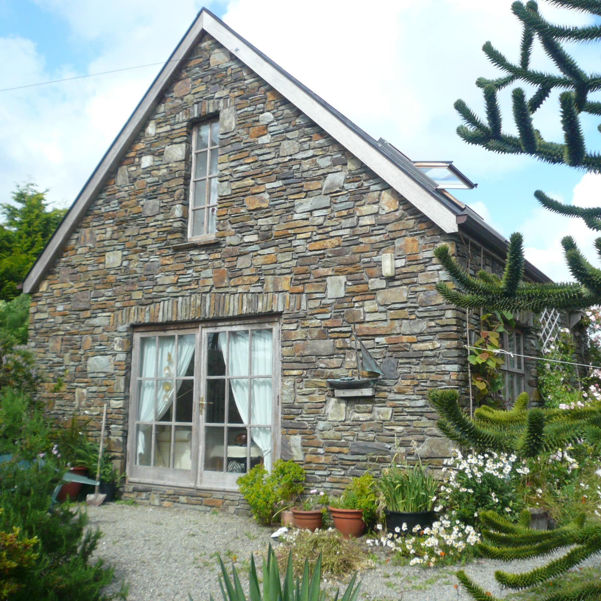 Ein Ferienhaus in Irland aus Stein umgeben von einem Garten