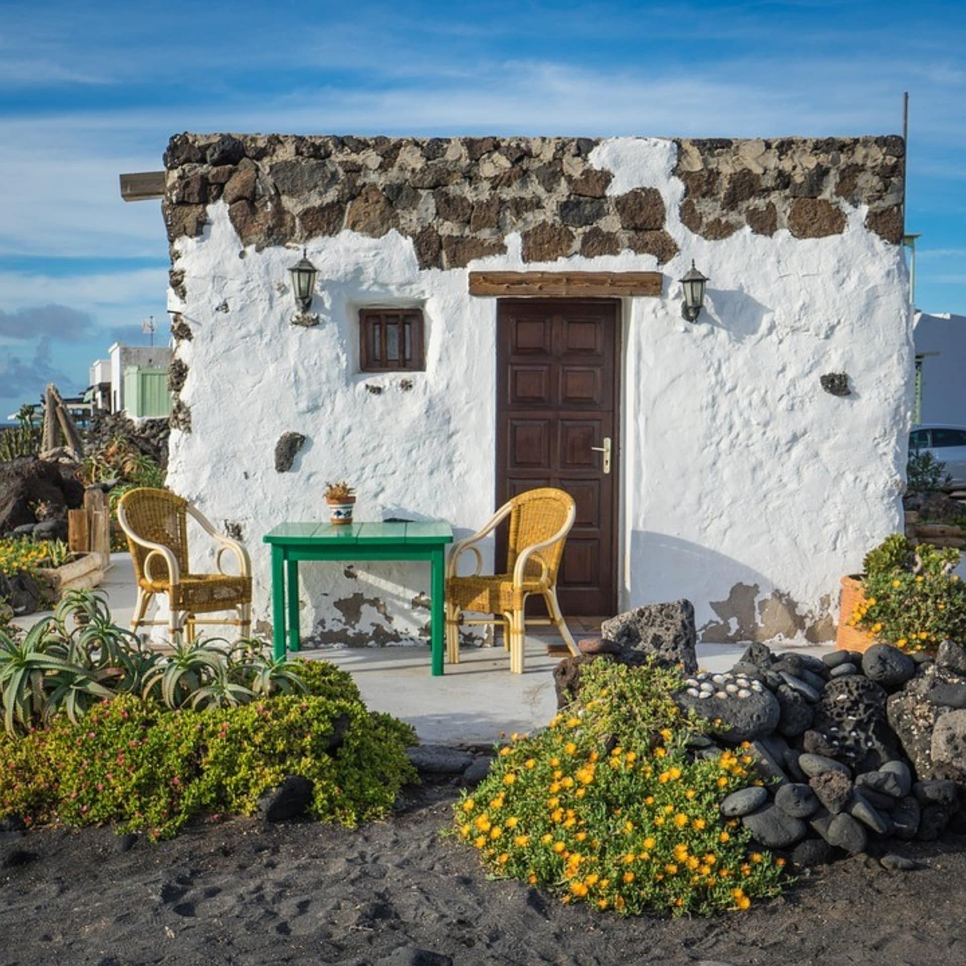 Kleine rustikale Finca mit Tisch und Stühlen auf der Veranda