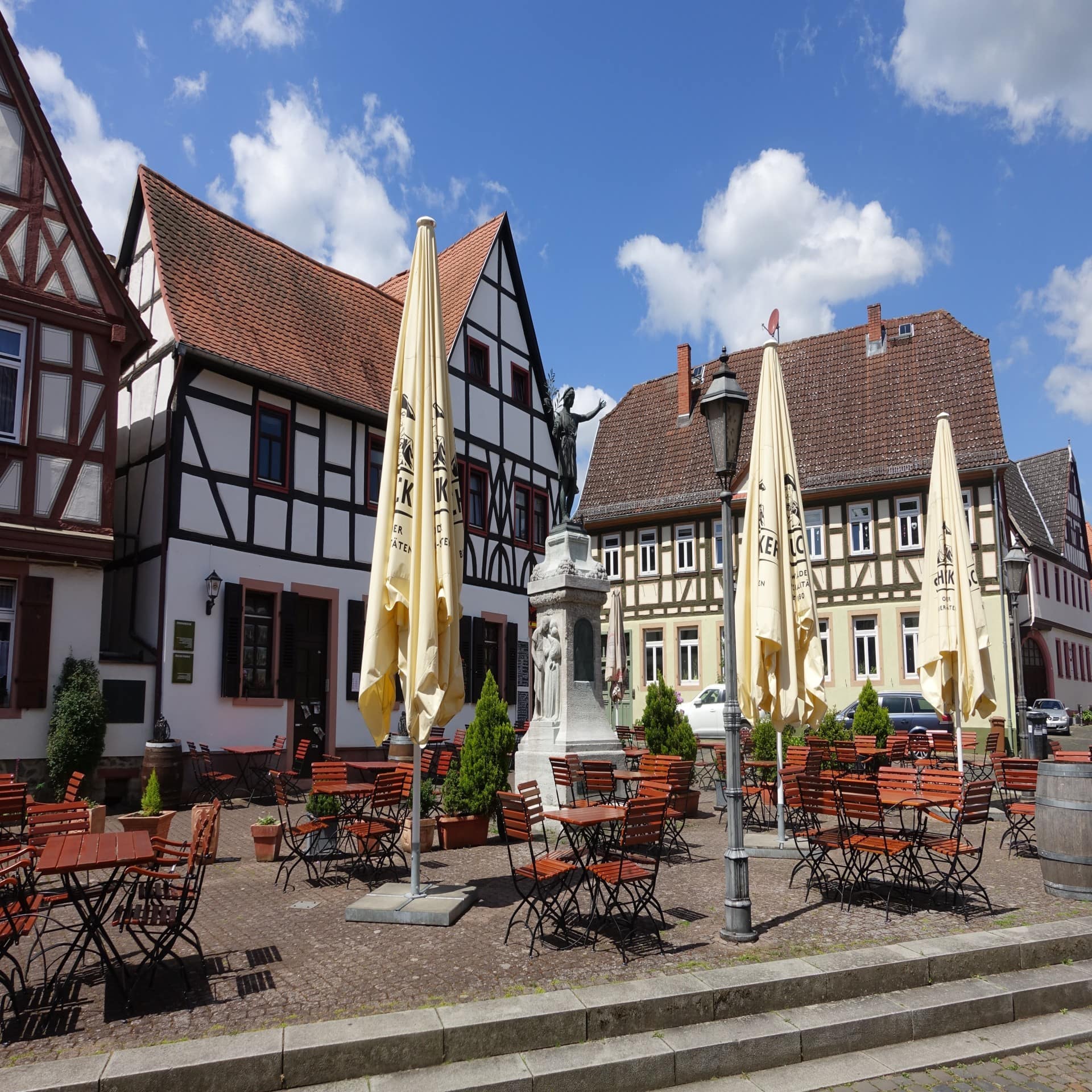 Fachwerkhäuser und Tische und Stühle in der Altstadt von Hanau.