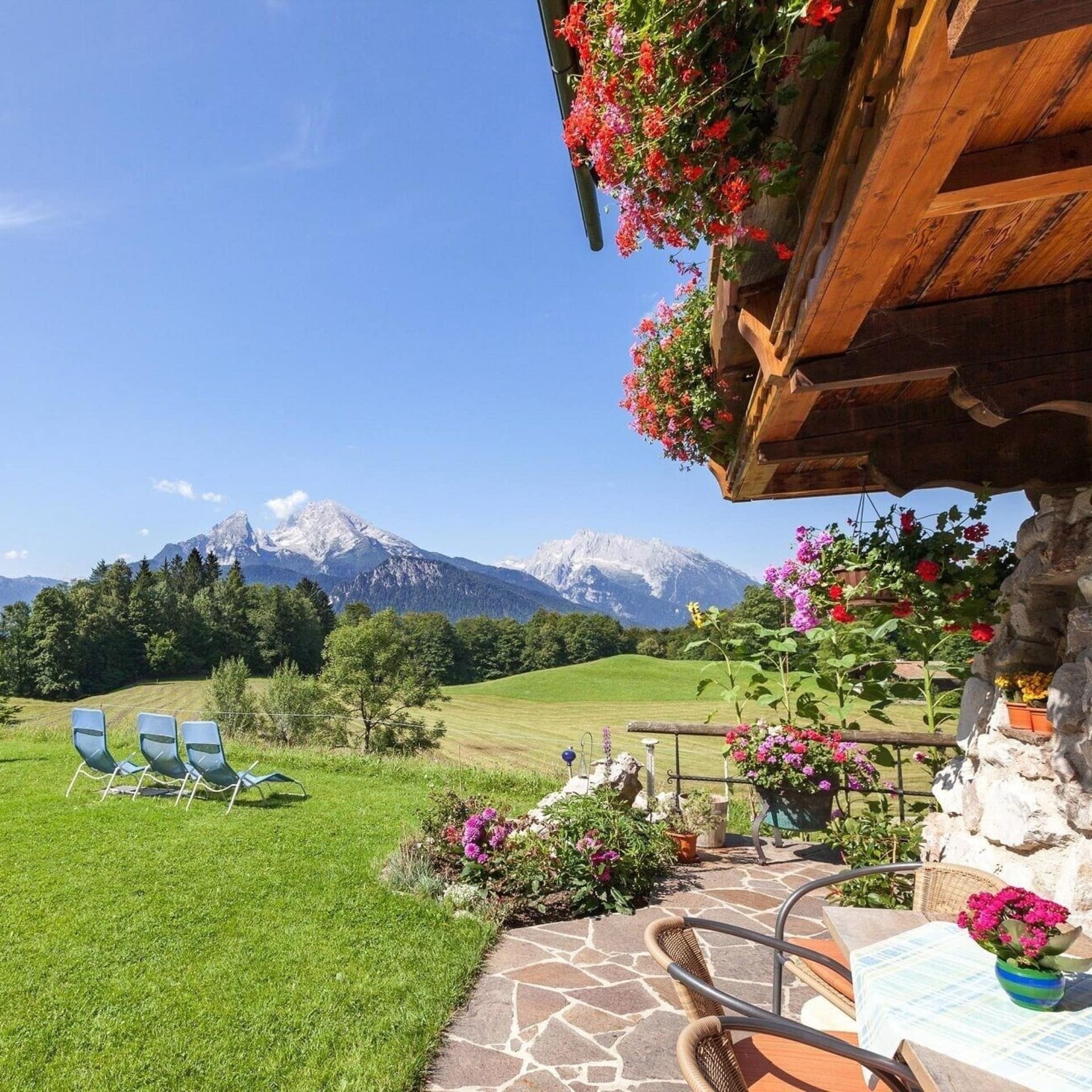 Terrasse und Wiese eines Ferienhauses in Berchtesgaden, mit Blick auf die Berge.