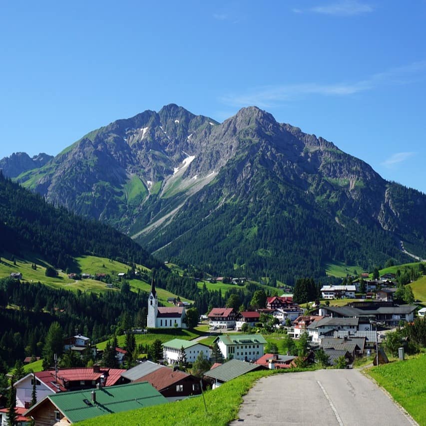 Blick auf ein Bergdorf in Osterreich inmitten der grünen Berghänge