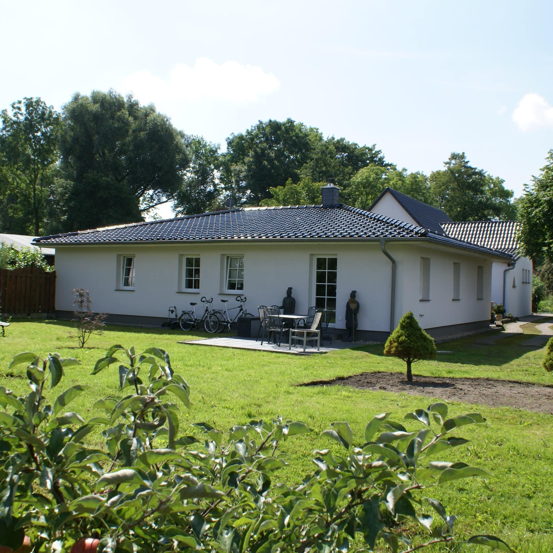 Blick auf einen ebenerdigen Bungalow in Graal-Müritz mit großem Garten