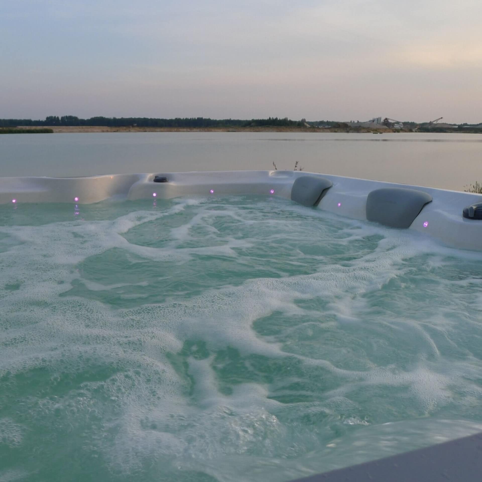 Whirlpool auf einer Terrasse mit Blick auf einen See in Sachsen. Sonnenuntergang.