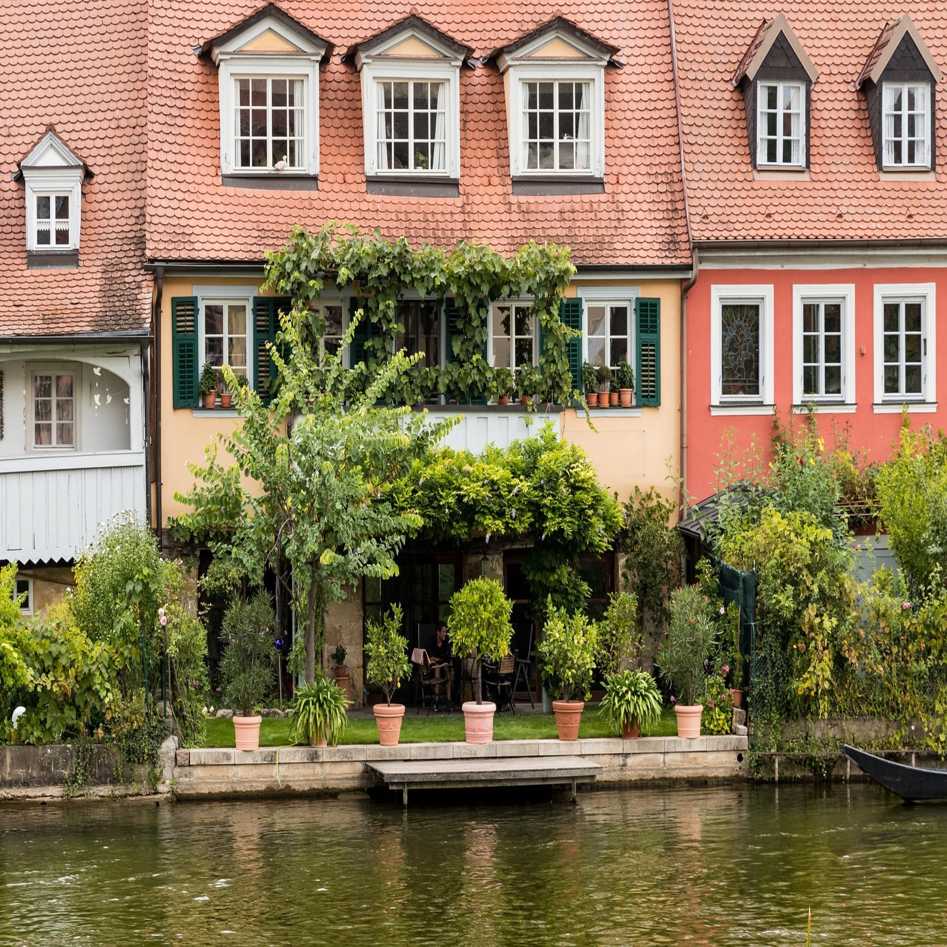 Blick über das Wasser auf Häuser mit Gärten direkt am Wasser