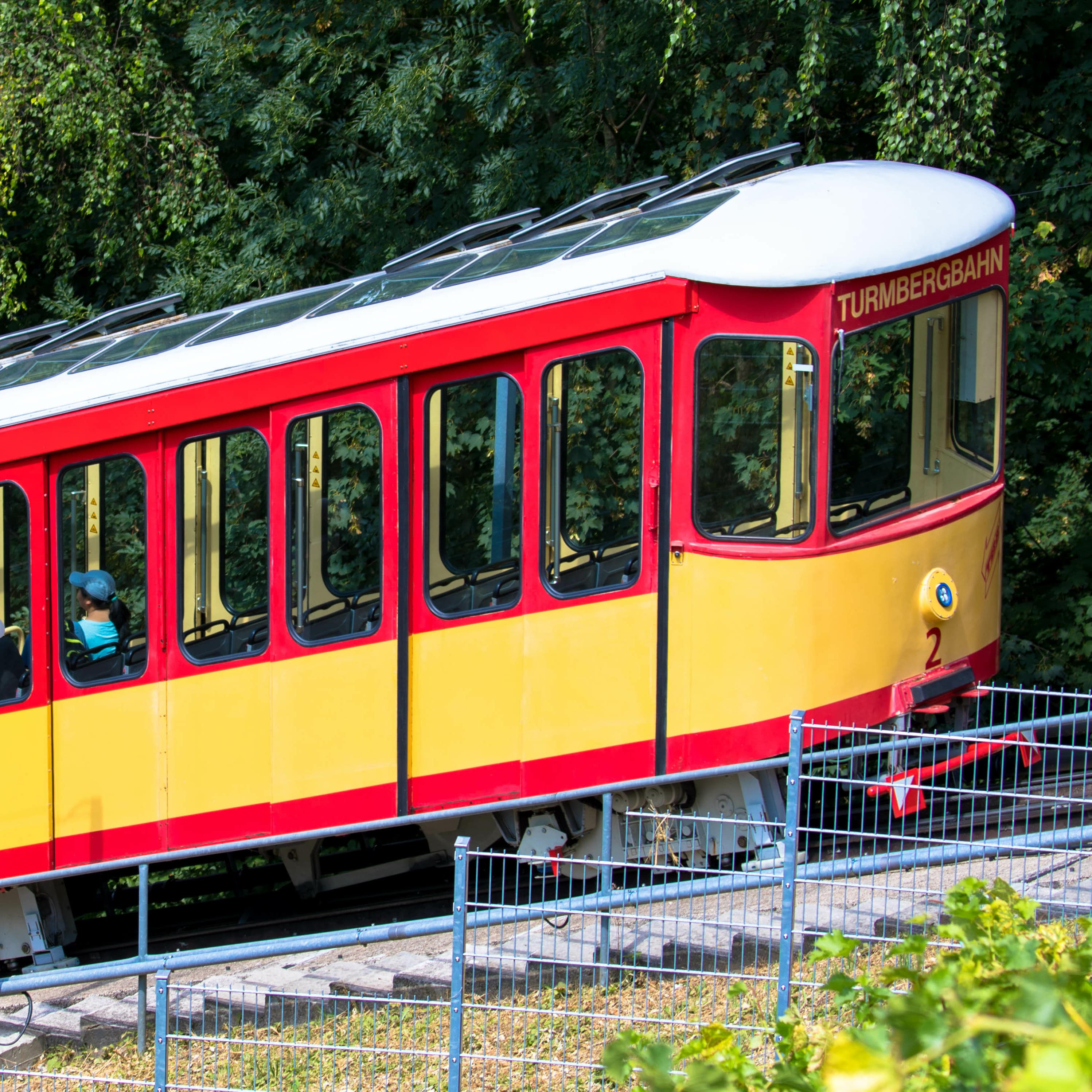 Die gelb-rote Turmbergbahn tuckert den Berg hoch.