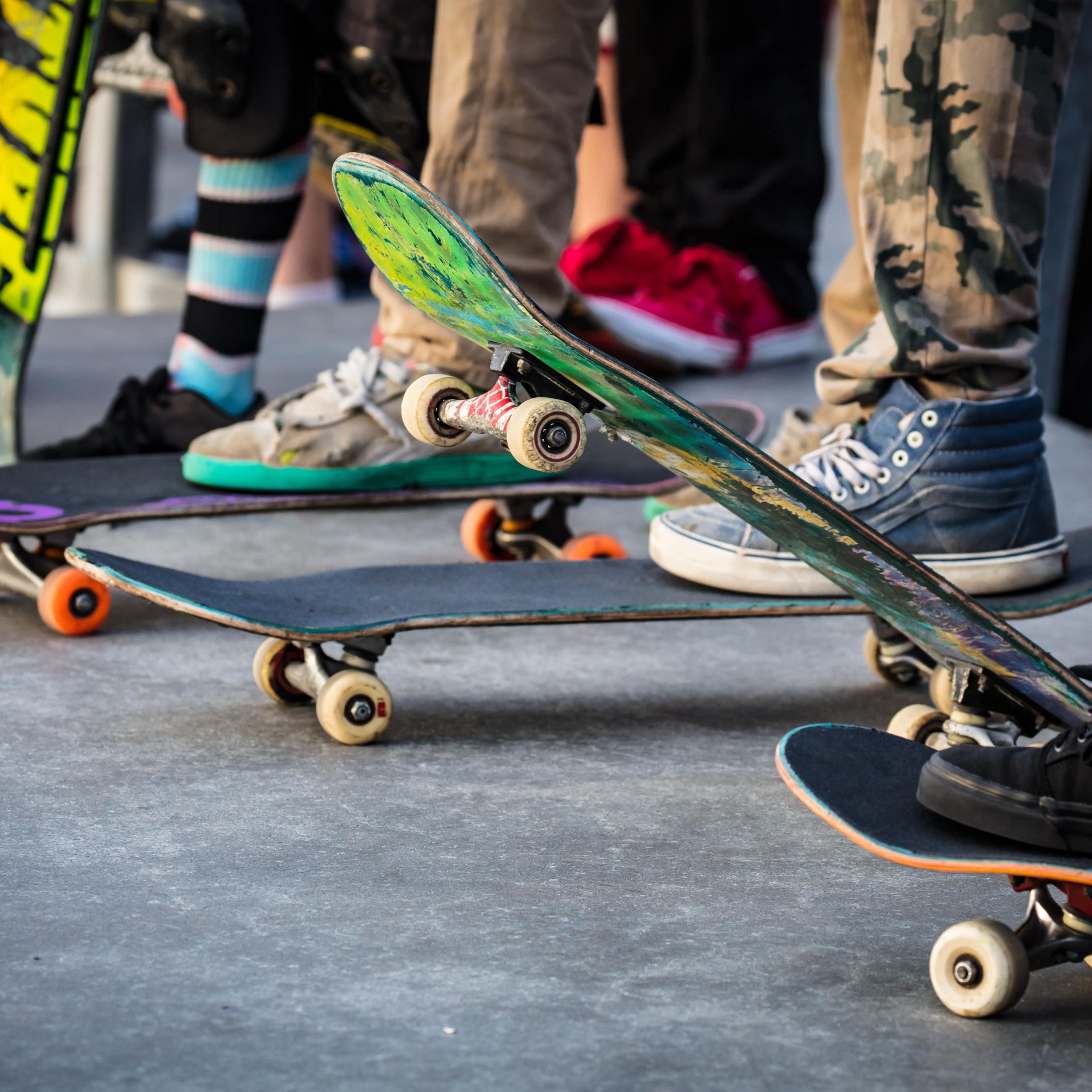 Nahaufnahme: Skateboards mit Beinen drauf.