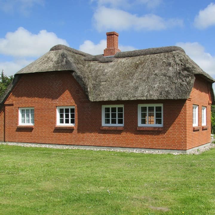 Rot verklinkerte Fassaden, weiße Sprossenfenster und Reetdächer – dieses dänische Ferienhaus für Familien ist typisch für Ferienhäuser auf Jütland