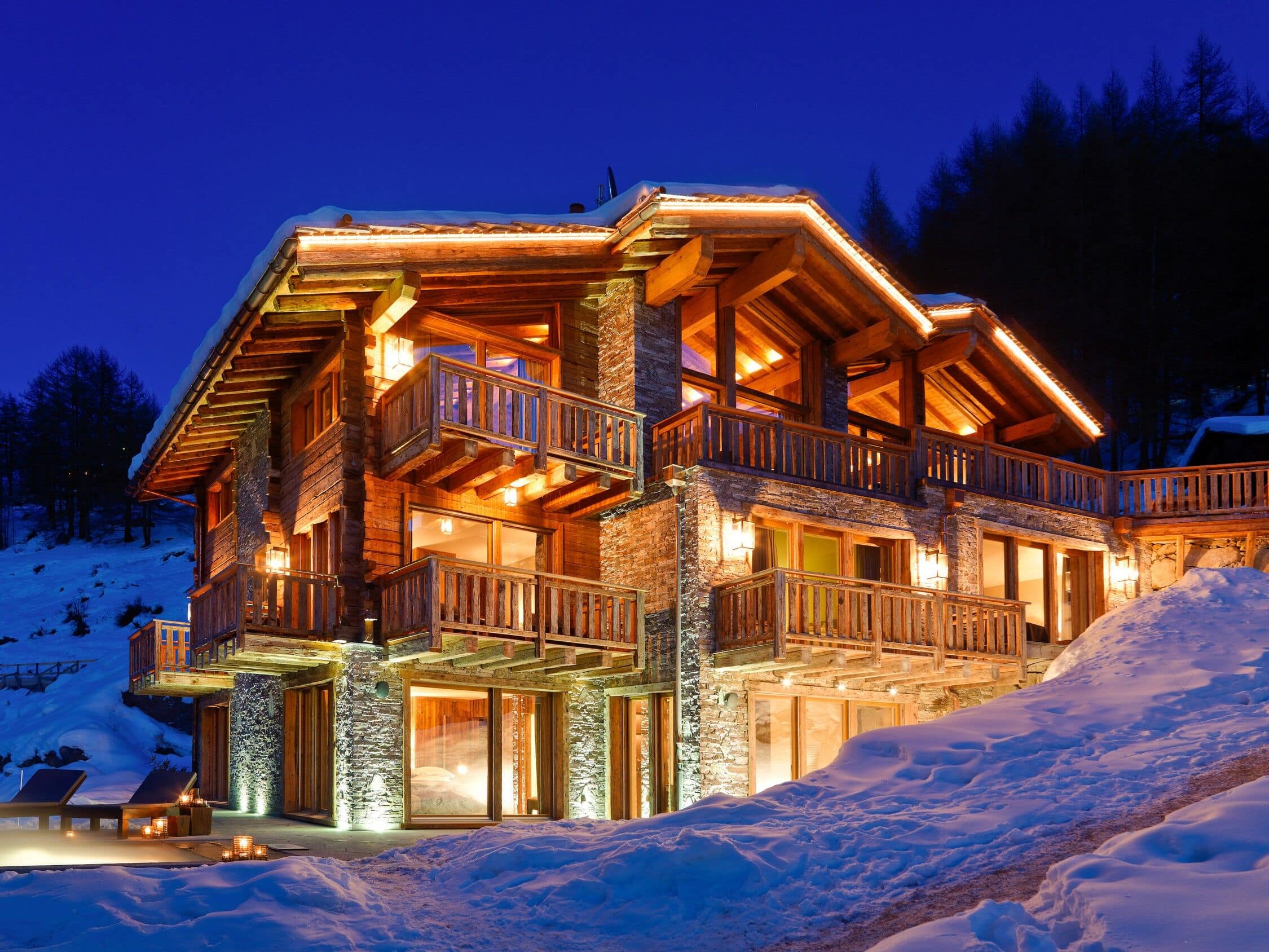 Hell erleuchtetes Chalet mit beheiztem Außenpool im Winter