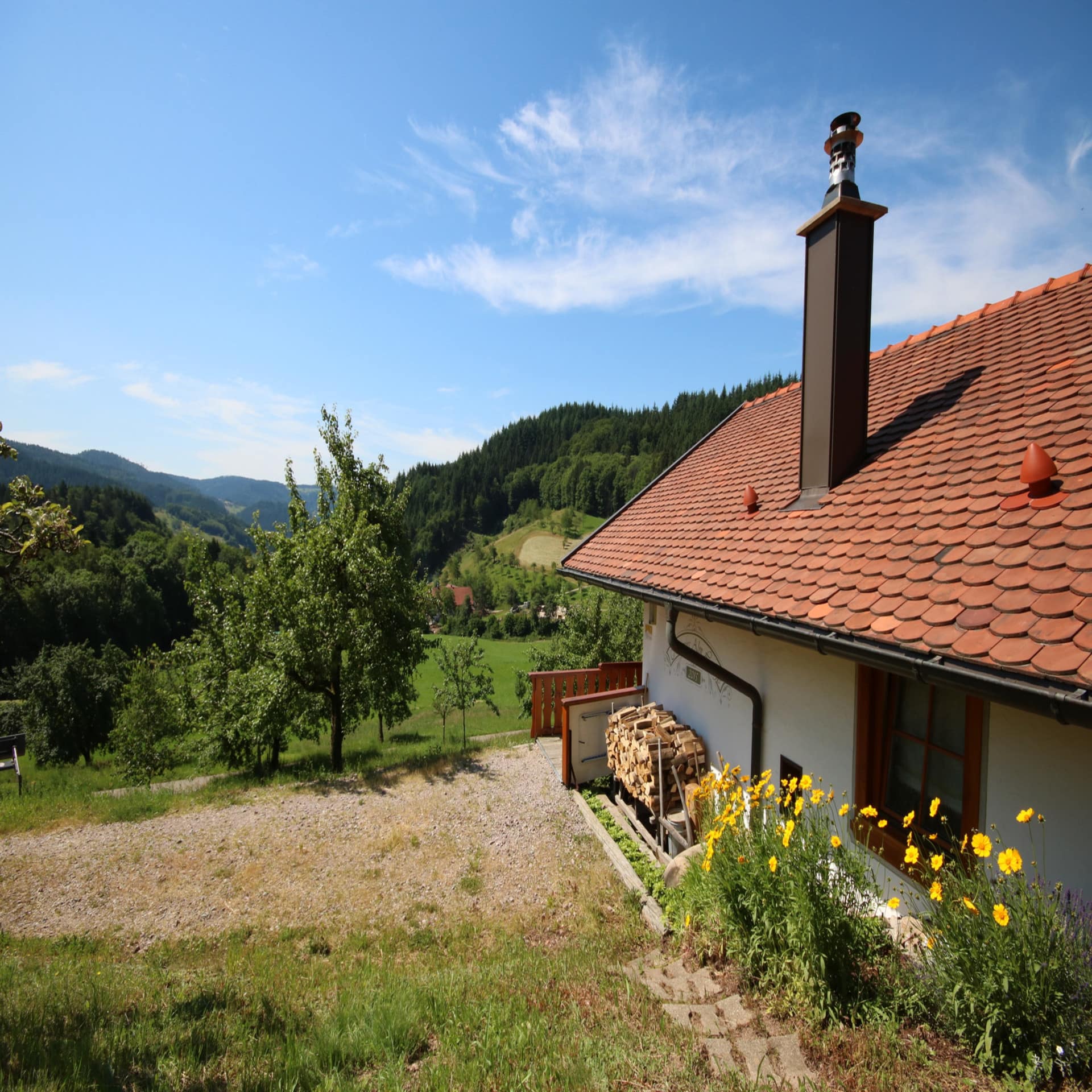 Eine Hütte in den Bergen mit Panoramablick. Die Sonne scheint. 