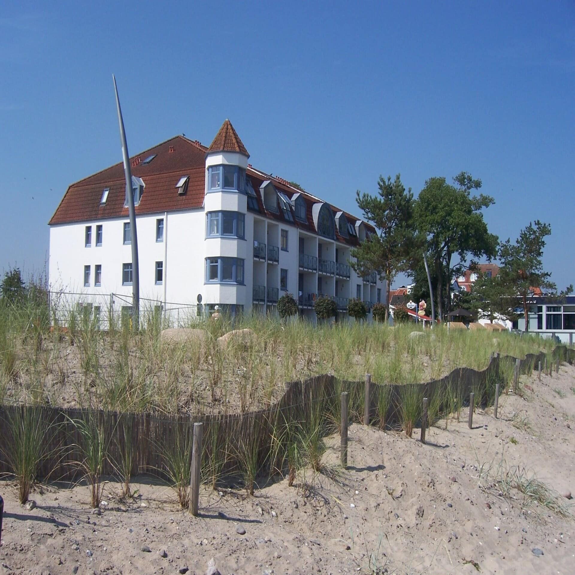 Wohngebäude direkt am Strand. Die Sonne scheint.