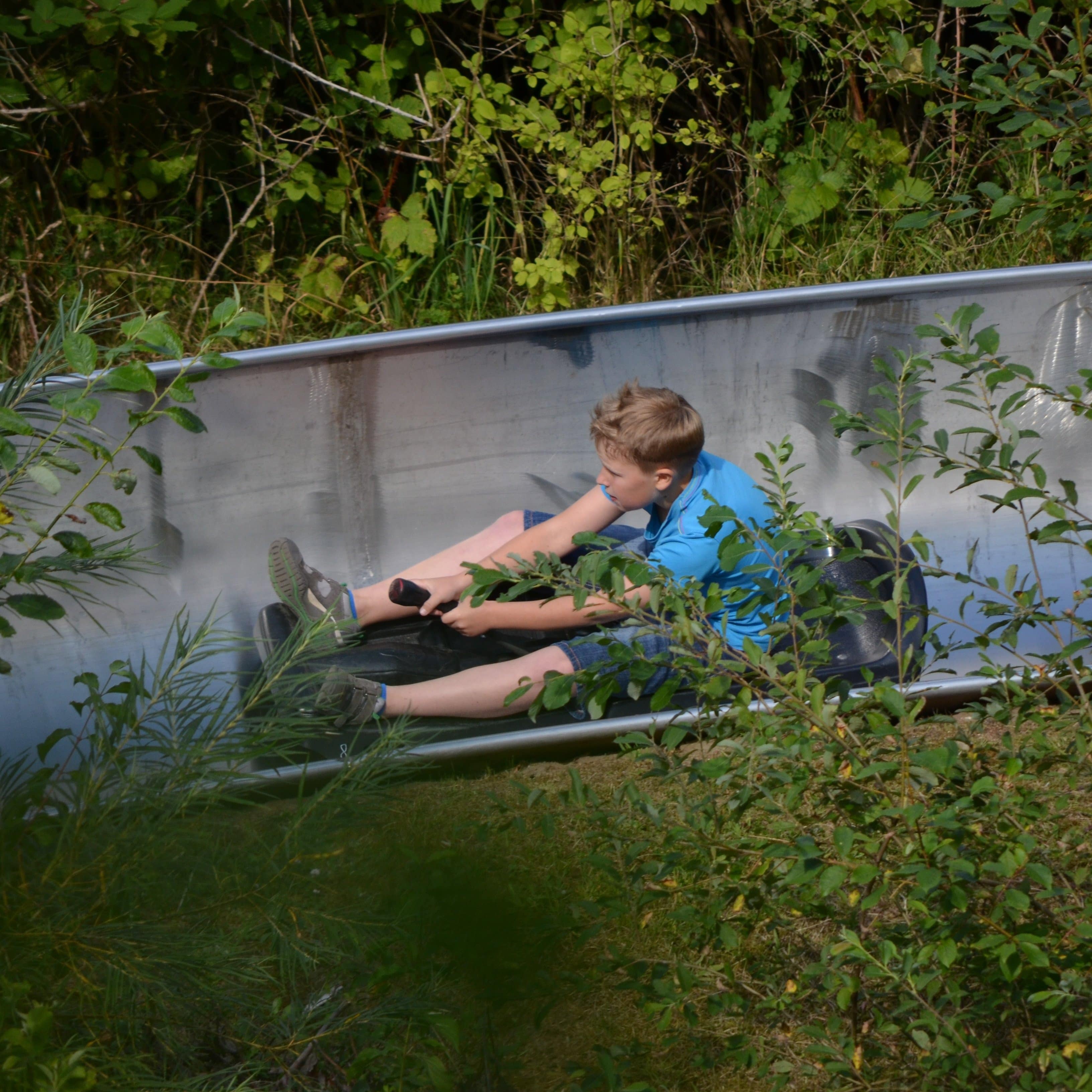 Ein Junge auf einer Sommerrodelbahn.