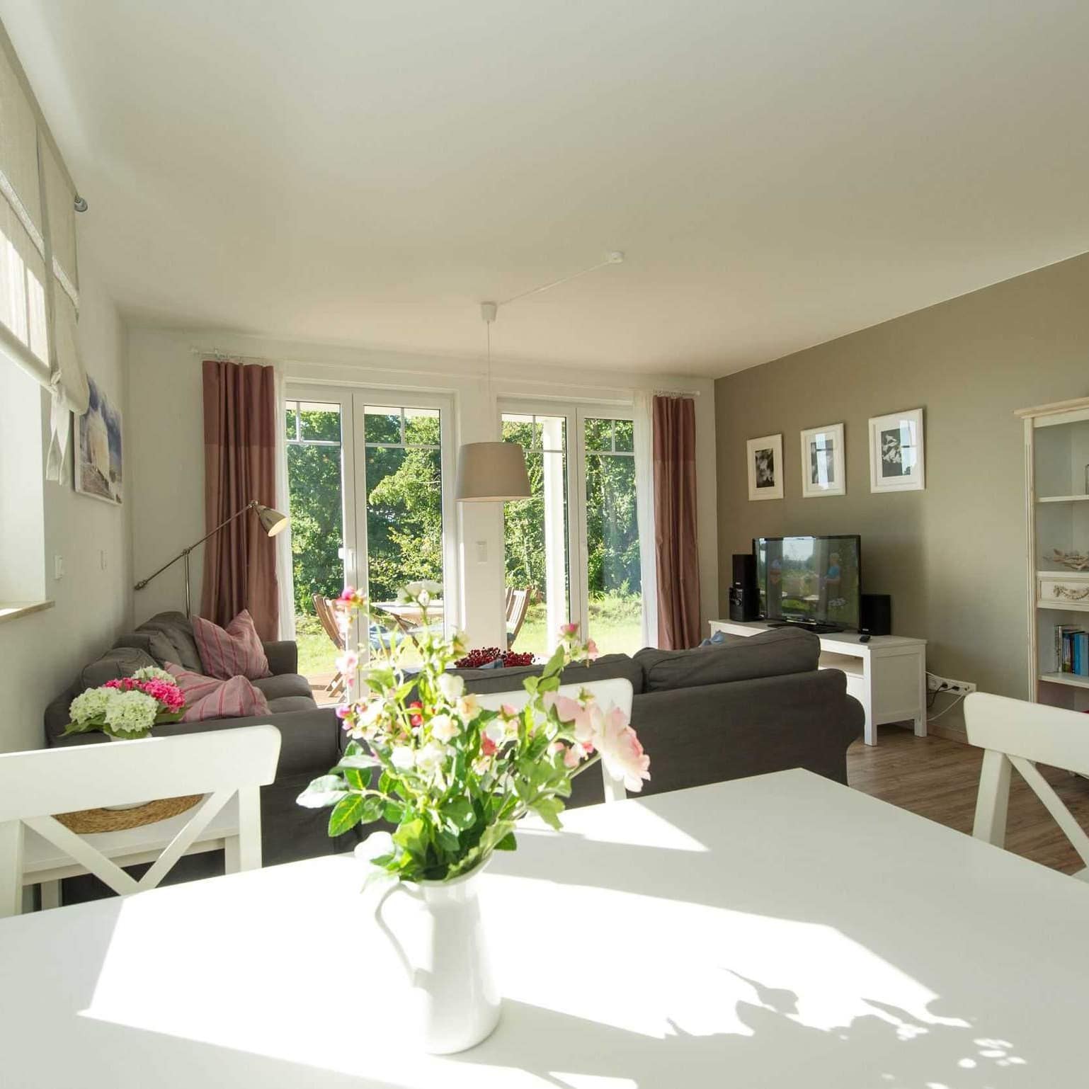 Lichtdurchflutetes Wohnzimmer einer Ferienwohnung in Göhren mit Garten