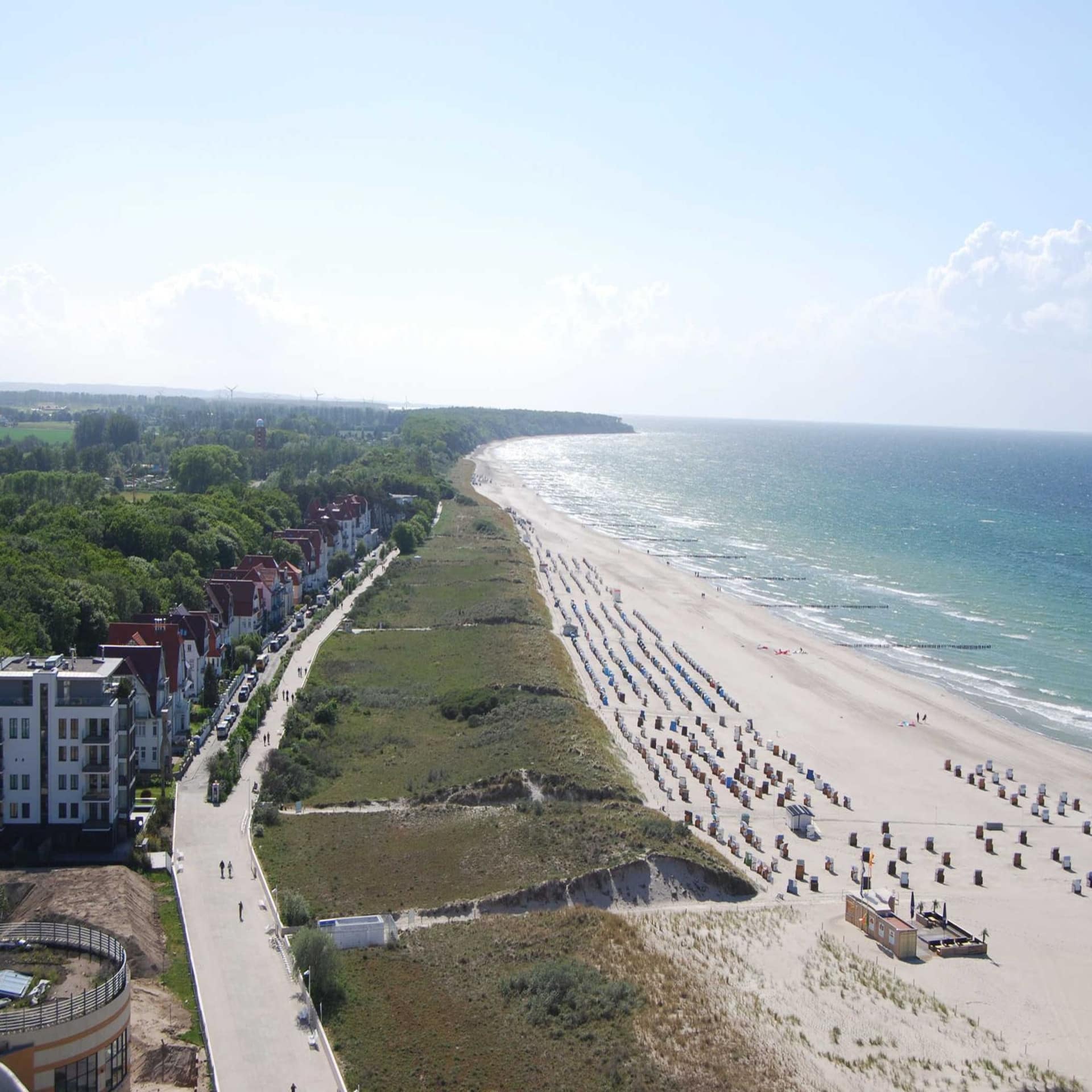 Blick von oben entlang der Strandpromenade, den Strand, das Meer und die Häuser. 