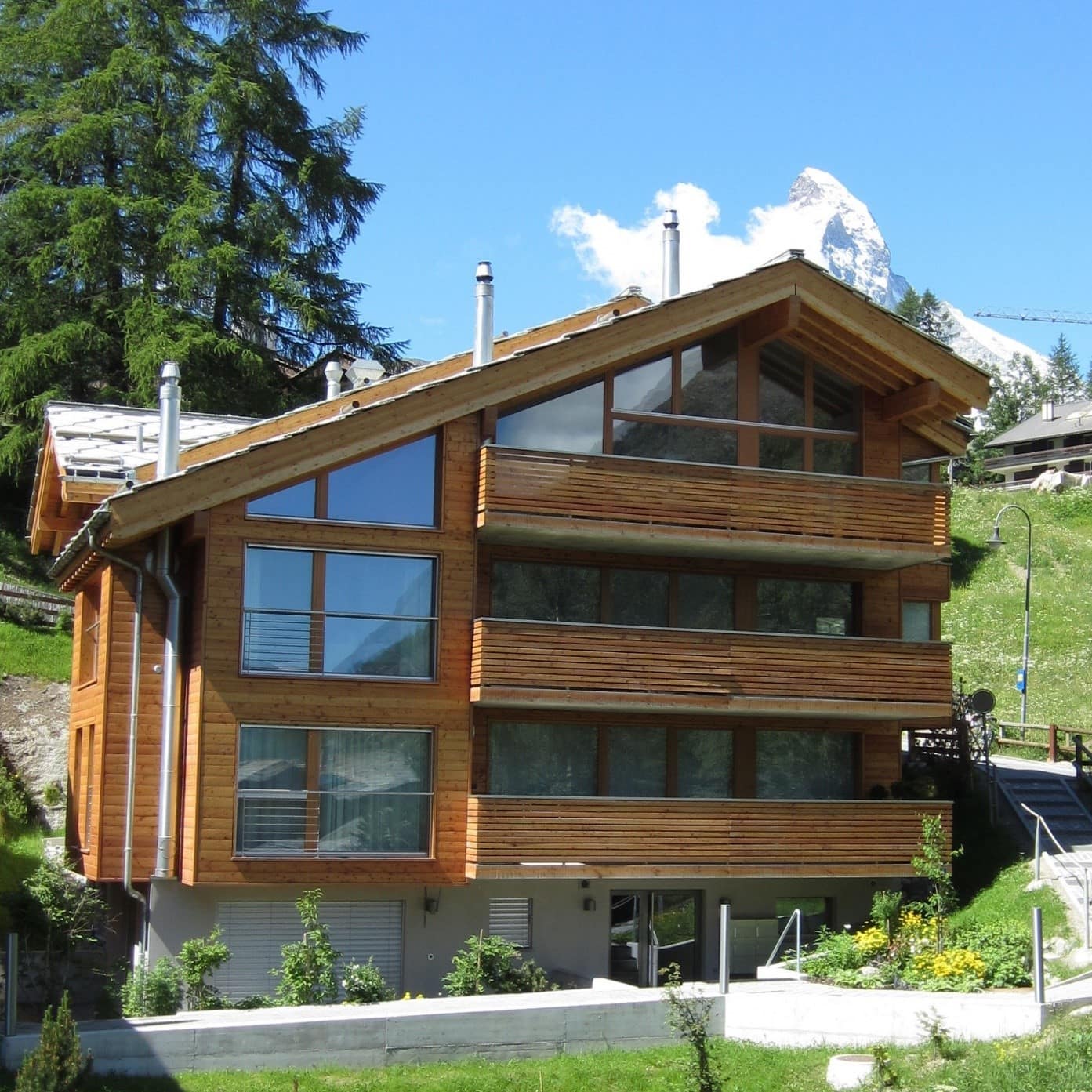 Modernes Chalet in den Alpen im Sommer vor Gebirge