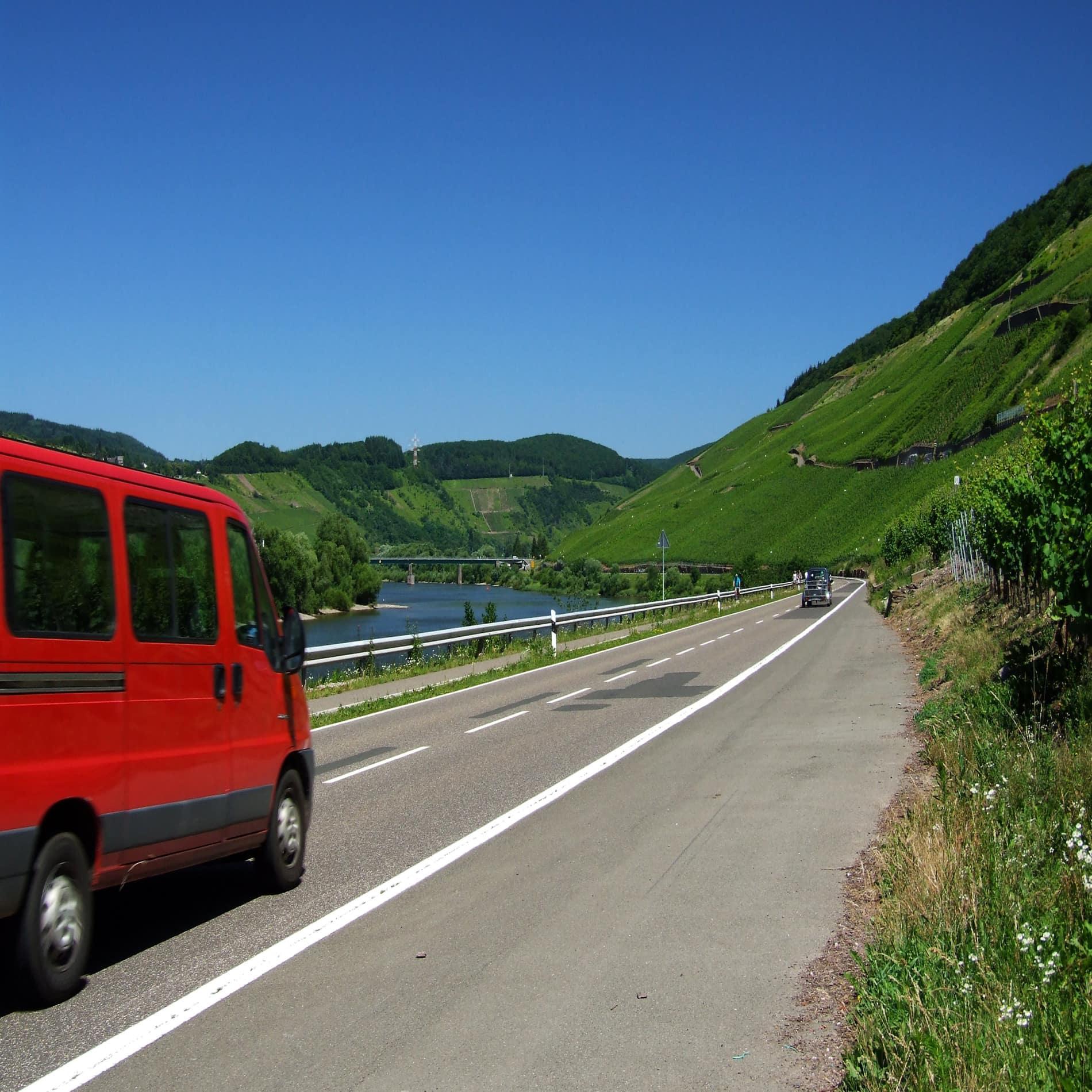 Straße entlang der Mosel, links ein rotes Auto.