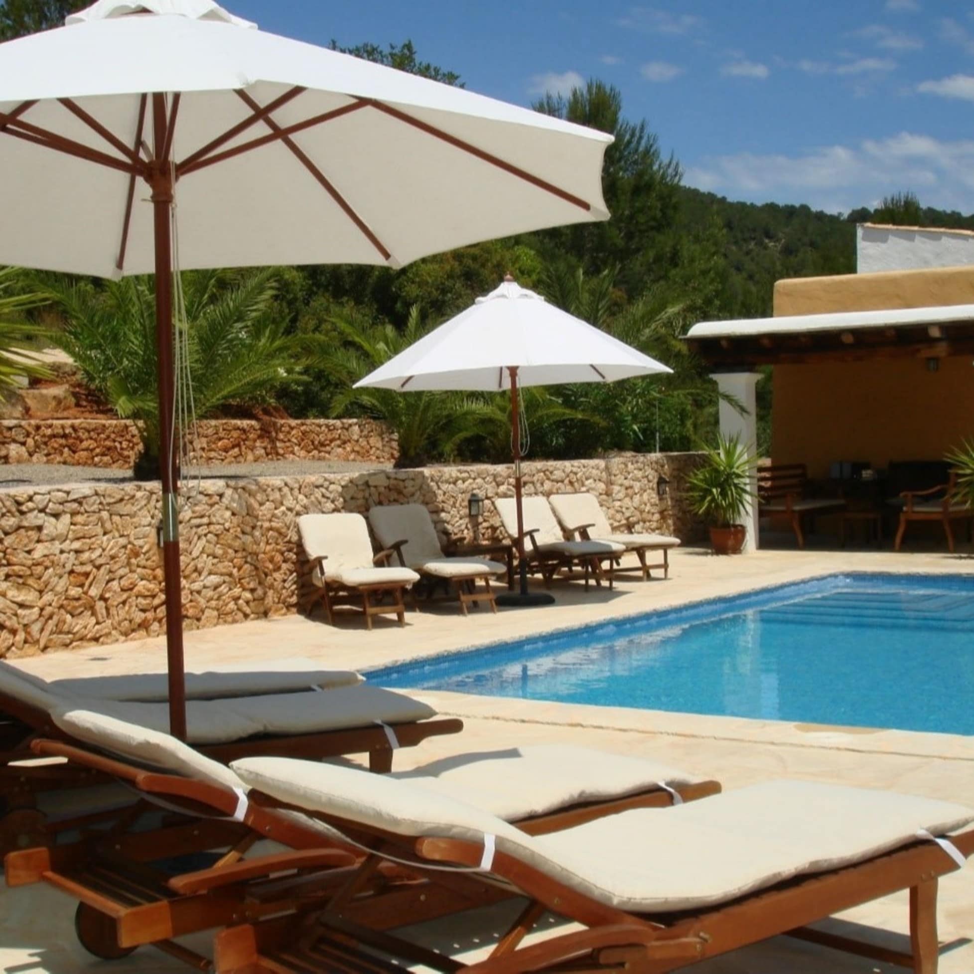 Finca auf Ibiza mit Pool, Sonnenliegen und Sonnenschirmen