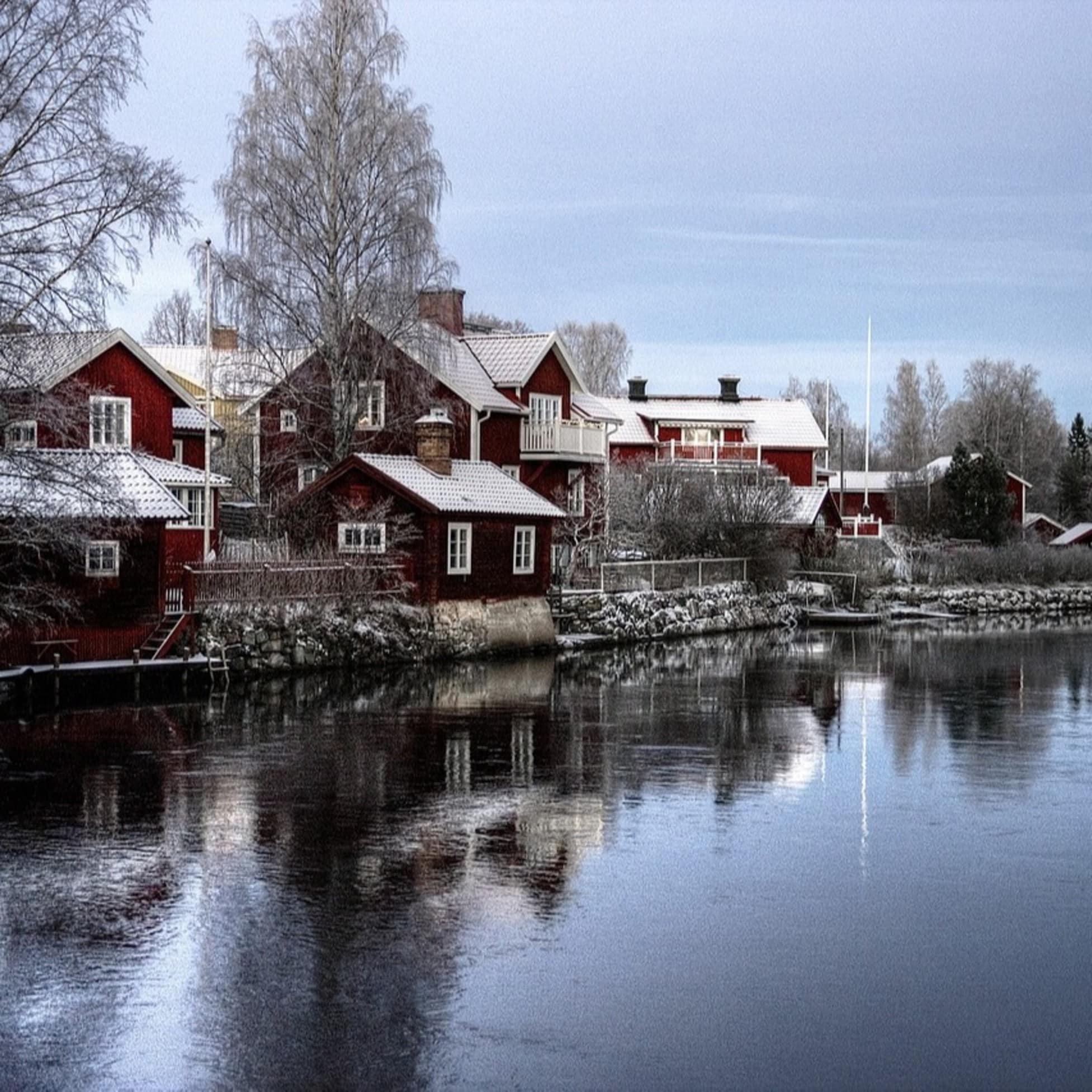 Luxusvillen am See in verschneiter Winterlandschaft