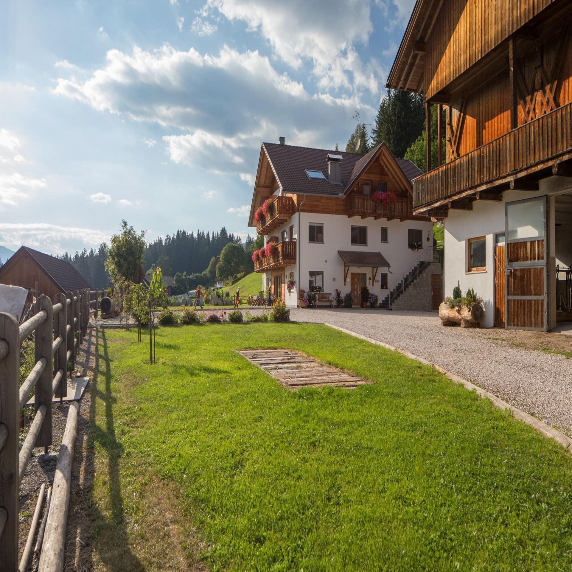 Seitenansicht: Bauernhof mit Scheune und einem Vorplatz. 